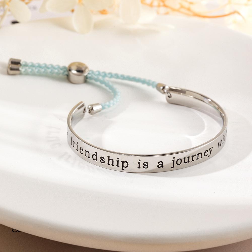 A stylish FRIENDSHIP BANGLE CUFF bracelet with an engraved charm reading 'A true friendship is a journey without an end', perfect for gifting.