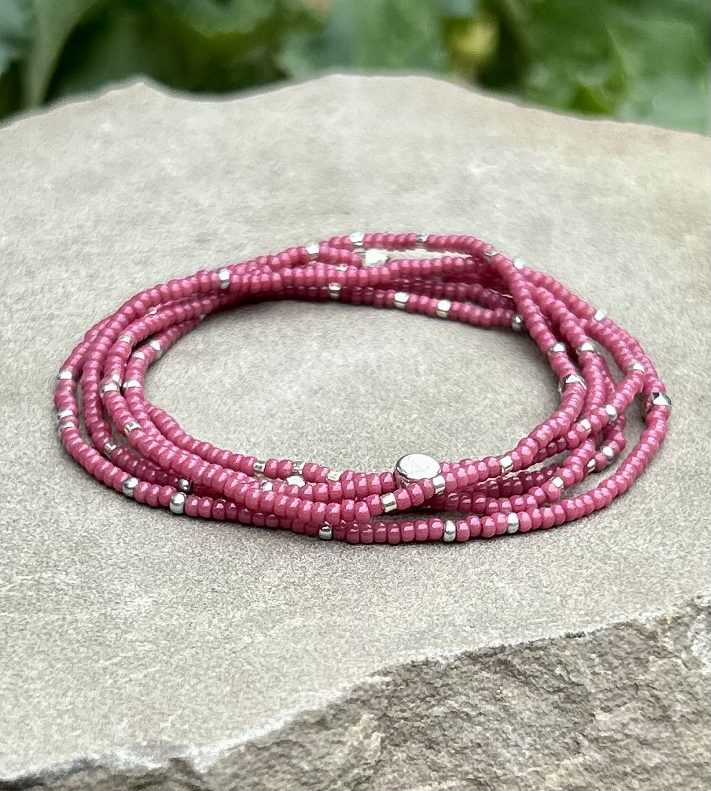 Fuchsia beaded 5-wrap bracelet with silver sprinkles on elastic cording, showcasing vibrant colors and intricate design.