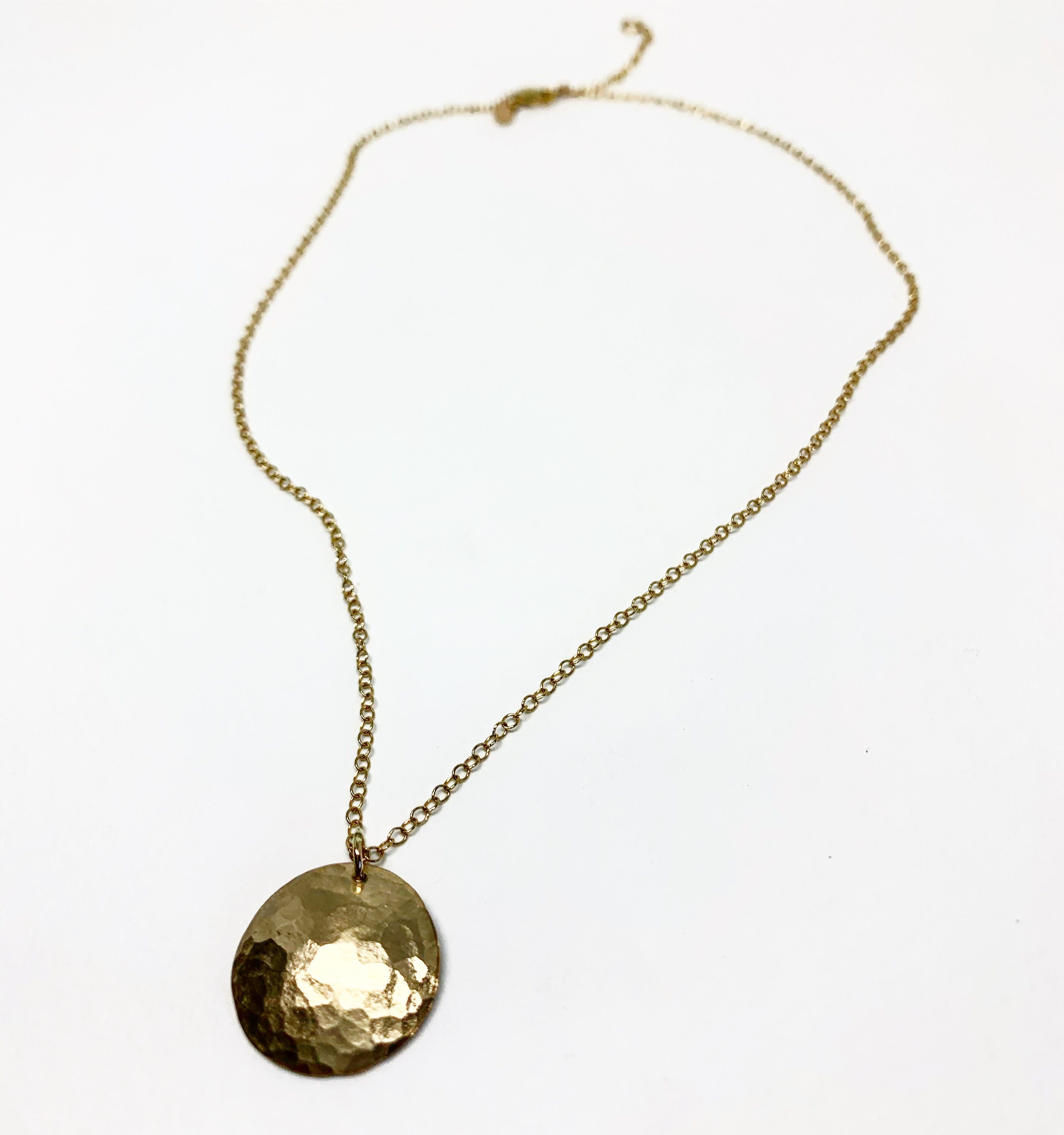 A beautifully crafted Full Moon Necklace featuring a hammered moon pendant, showcasing its unique texture and organic design.