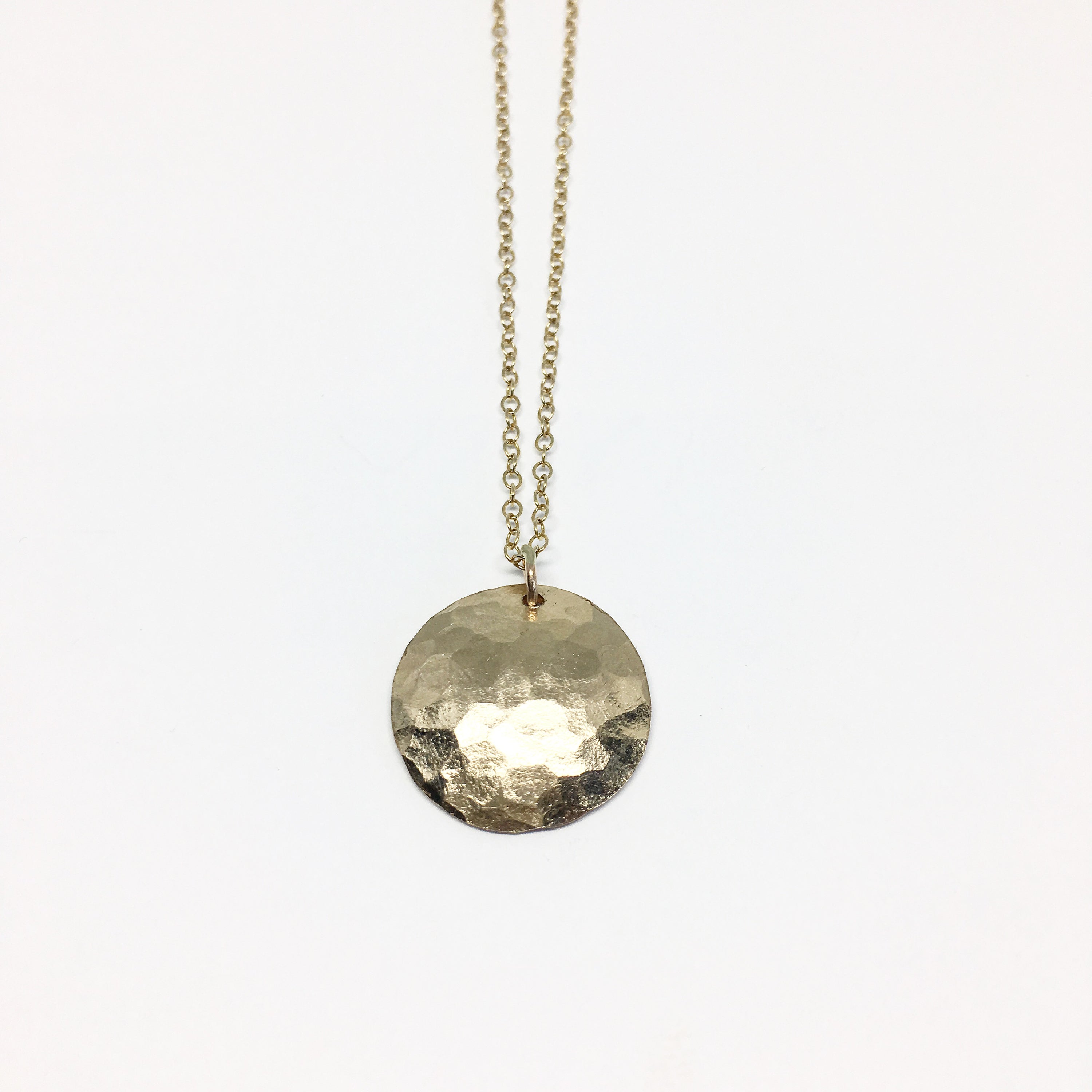 A beautifully crafted Full Moon Necklace featuring a hammered moon pendant, showcasing its unique texture and organic design.