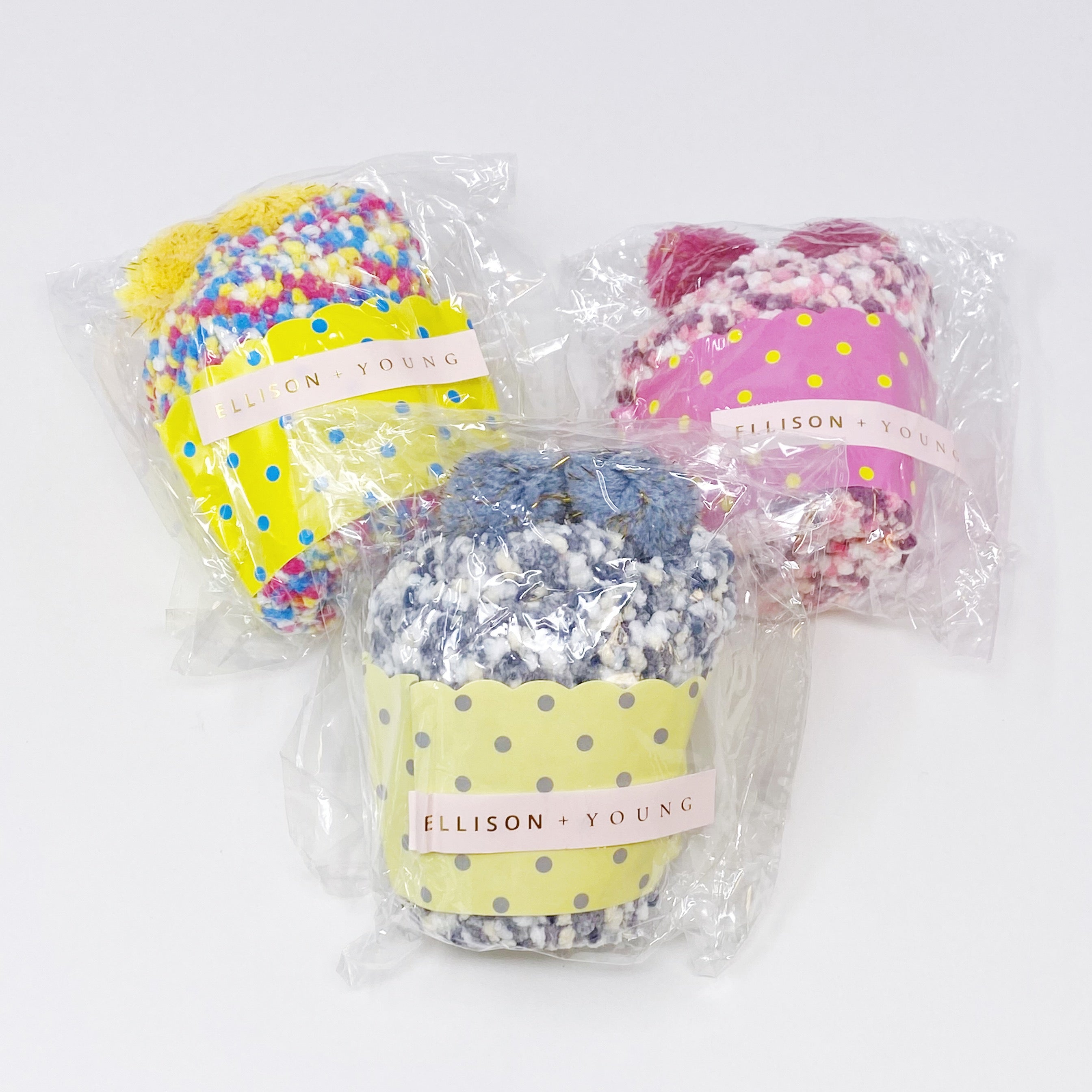 Soft and fuzzy Fuzzy Pom Confetti Socks with a cute pom detail on the back, displayed in cupcake packaging.