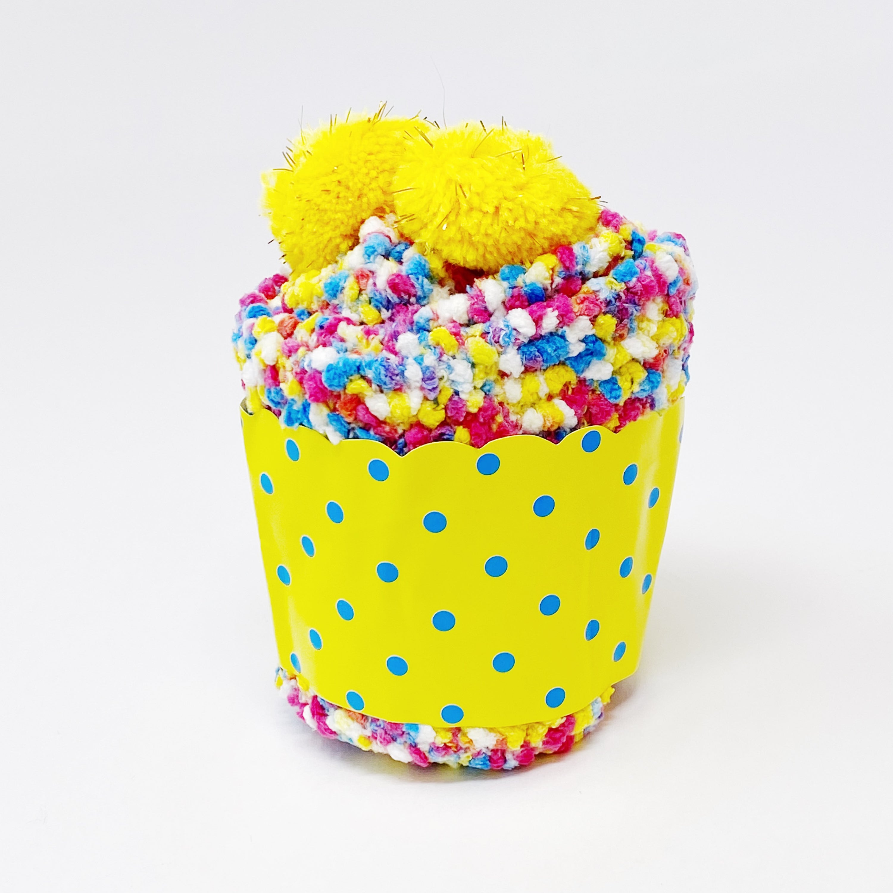 Soft and fuzzy Fuzzy Pom Confetti Socks with a cute pom detail on the back, displayed in cupcake packaging.