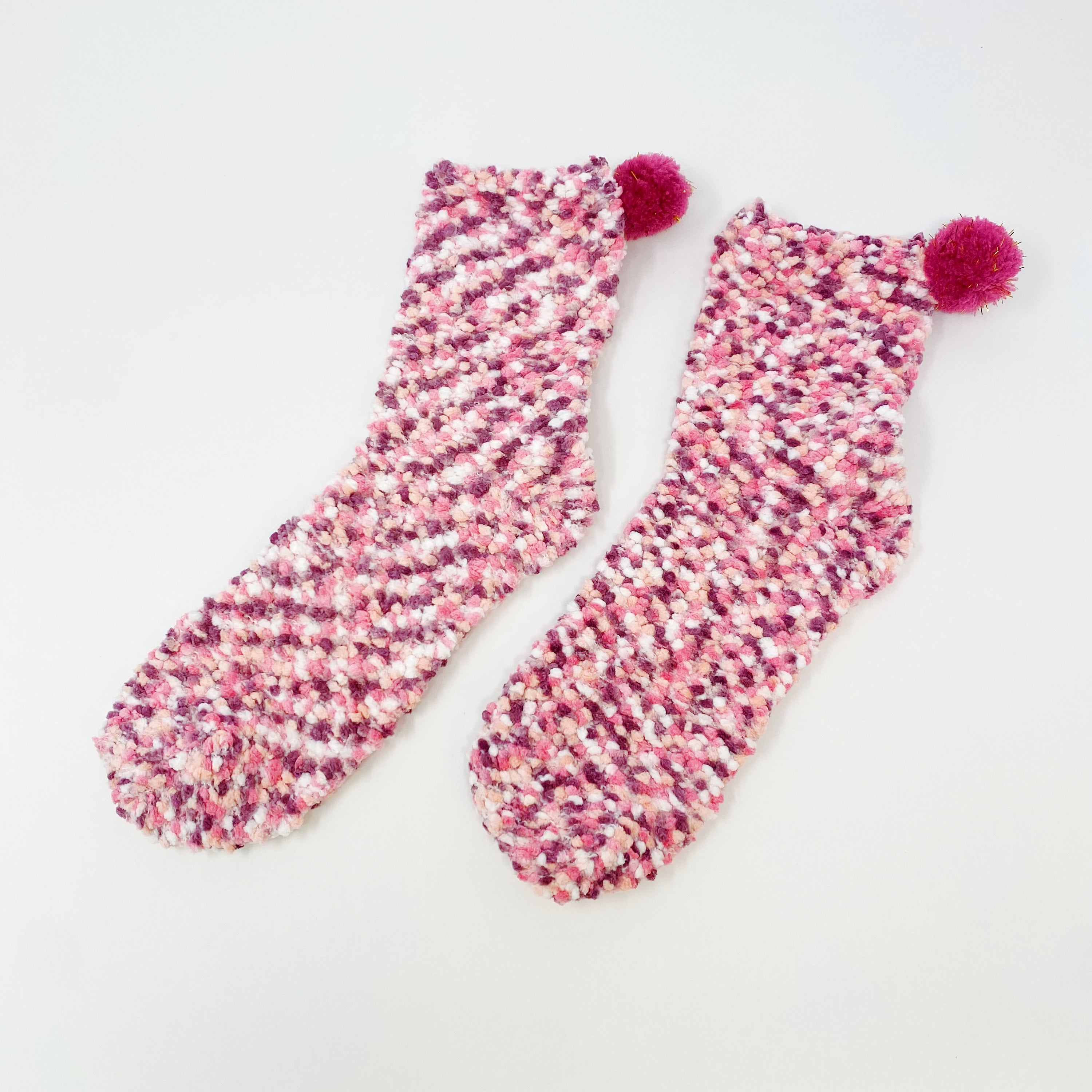 Soft and fuzzy Fuzzy Pom Confetti Socks with a cute pom detail on the back, displayed in cupcake packaging.