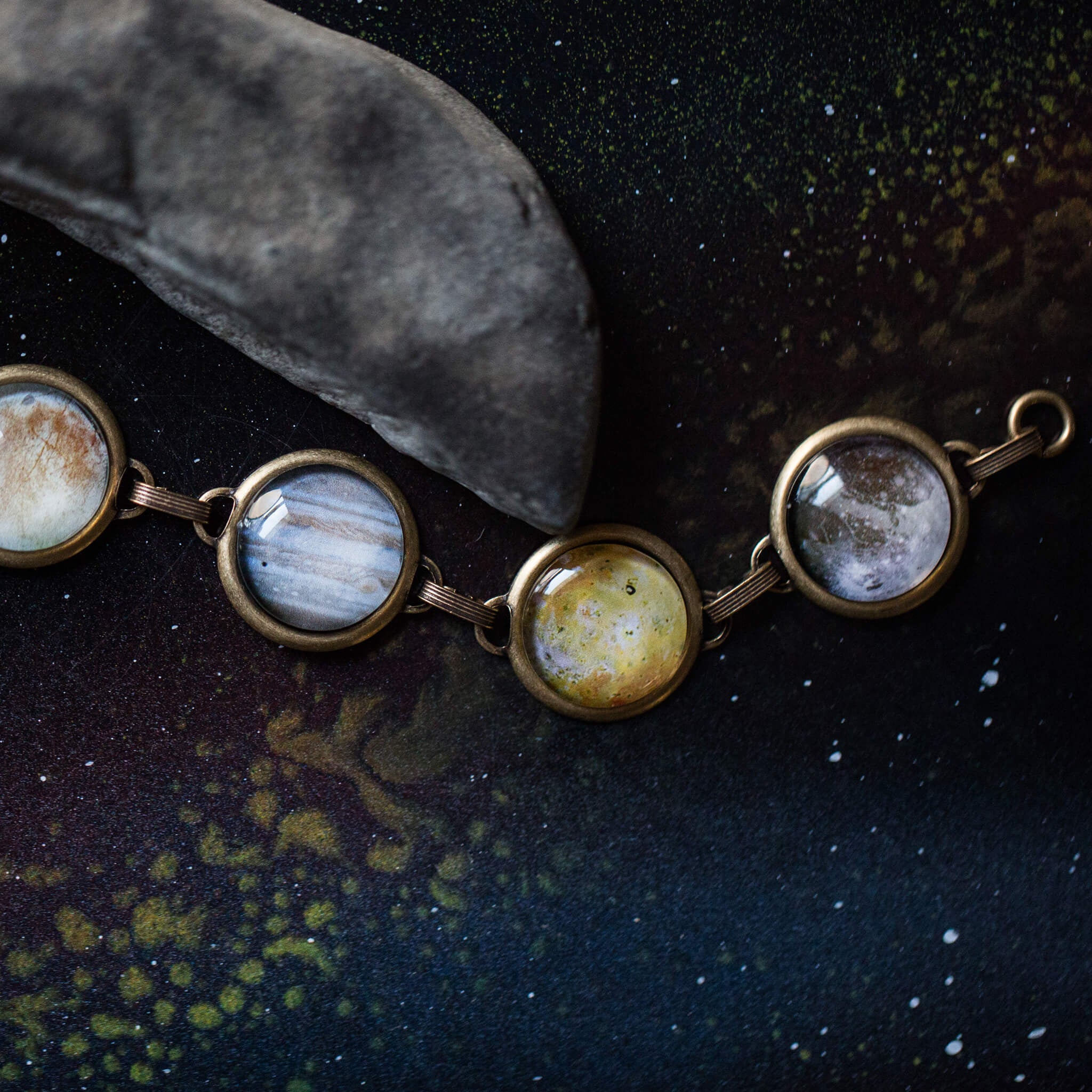 Galilean Moon Bracelet featuring images of Jupiter's four largest moons: Europa, Io, Ganymede, and Callisto, with a central image of Jupiter.