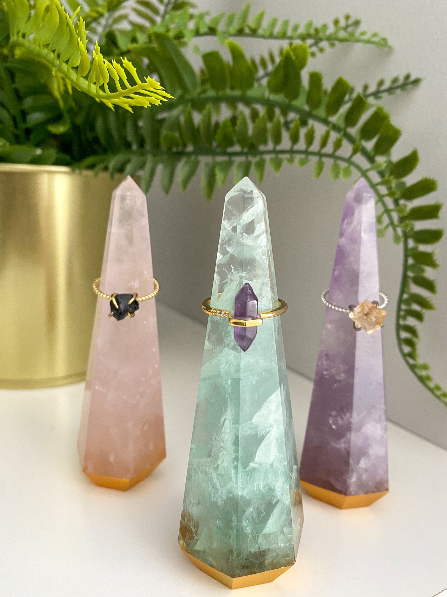 A beautifully handcrafted gemstone ring tower made from natural amethyst, rose quartz, and fluorite, standing 4 inches tall.