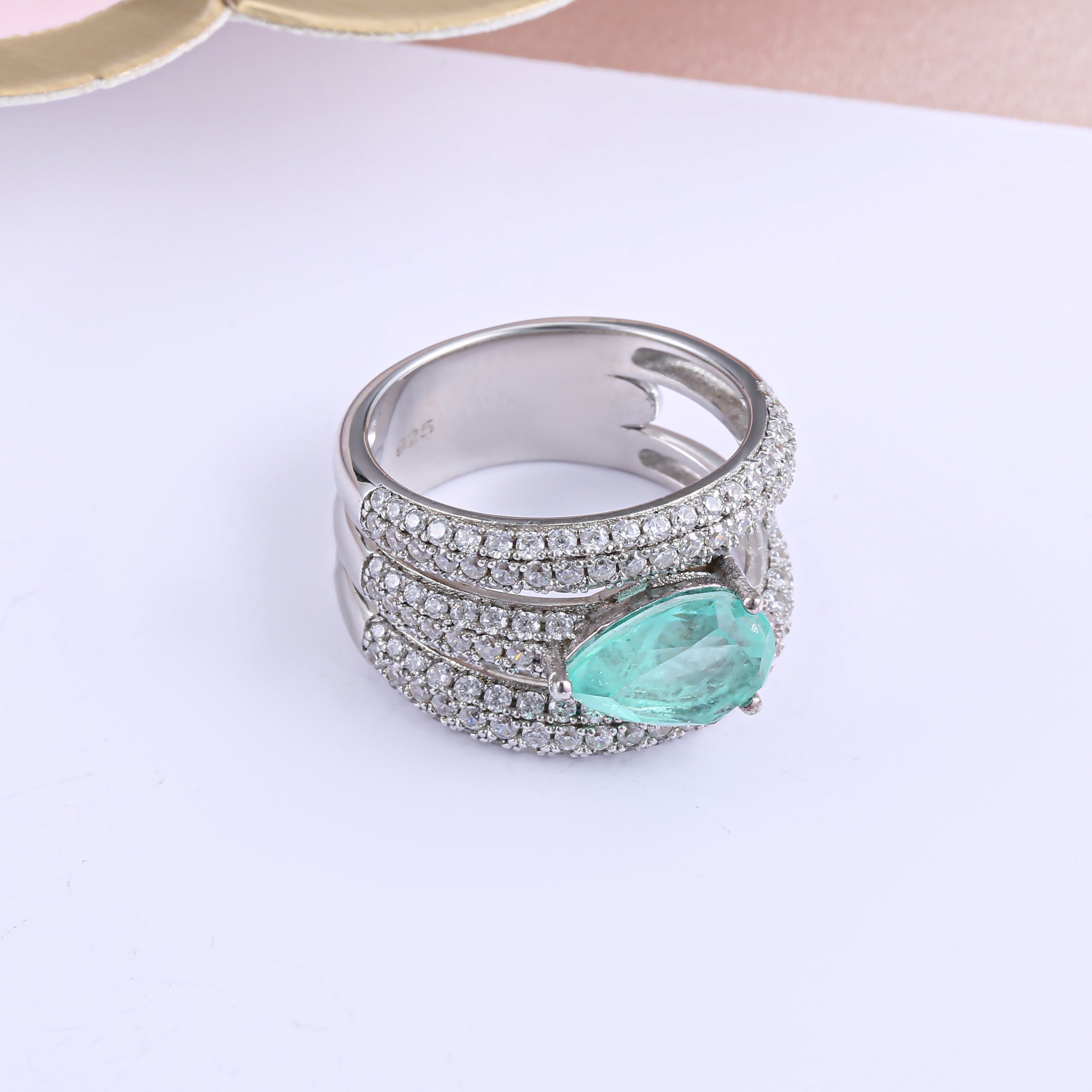 A stunning gemstone ring featuring a blue paraiba stone set in 925 sterling silver with a white gold finish, showcasing elegance and craftsmanship.