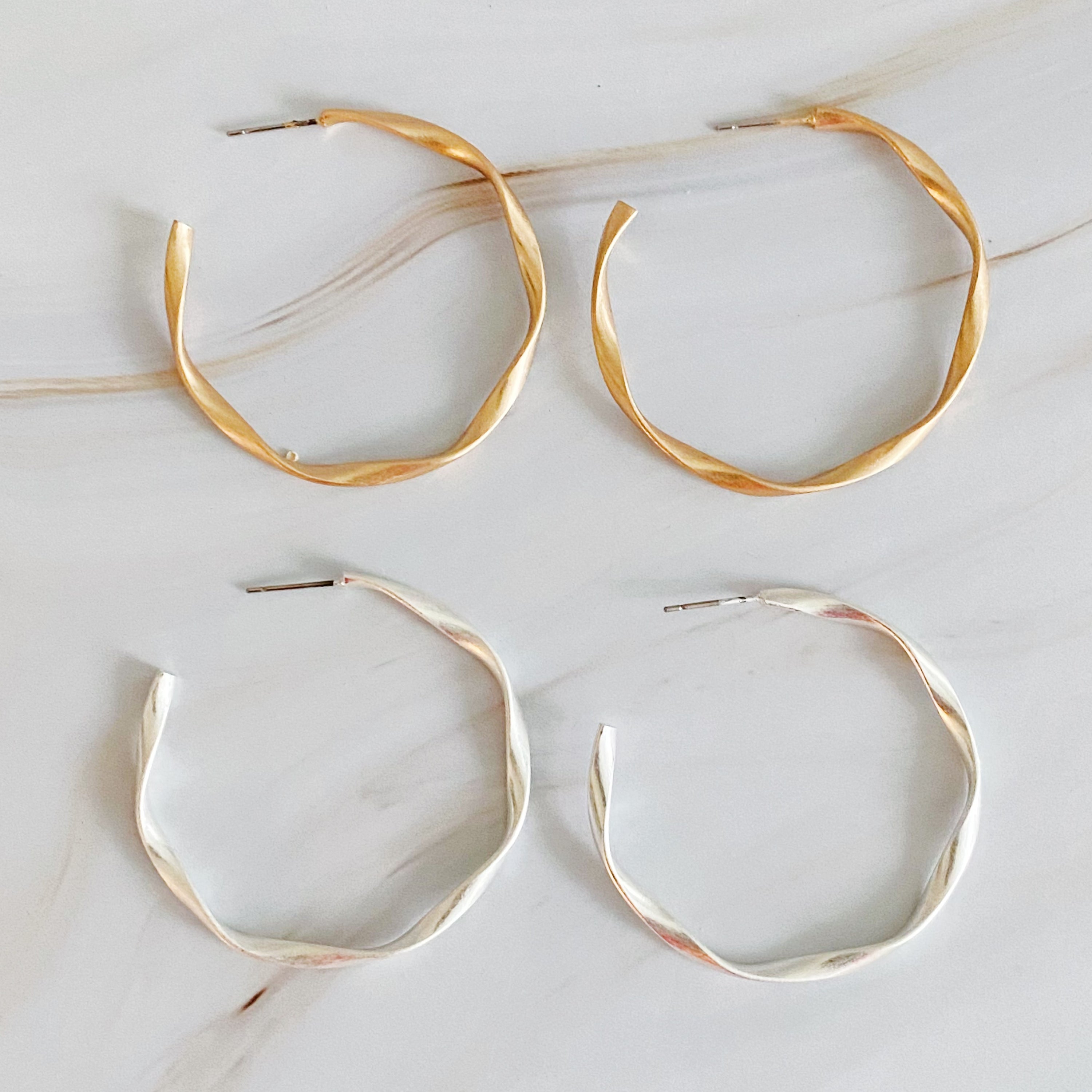 Gentle Wave Sleek Hoop Earrings with a softly twisted design and matte finish, showcasing their elegant and modern style.