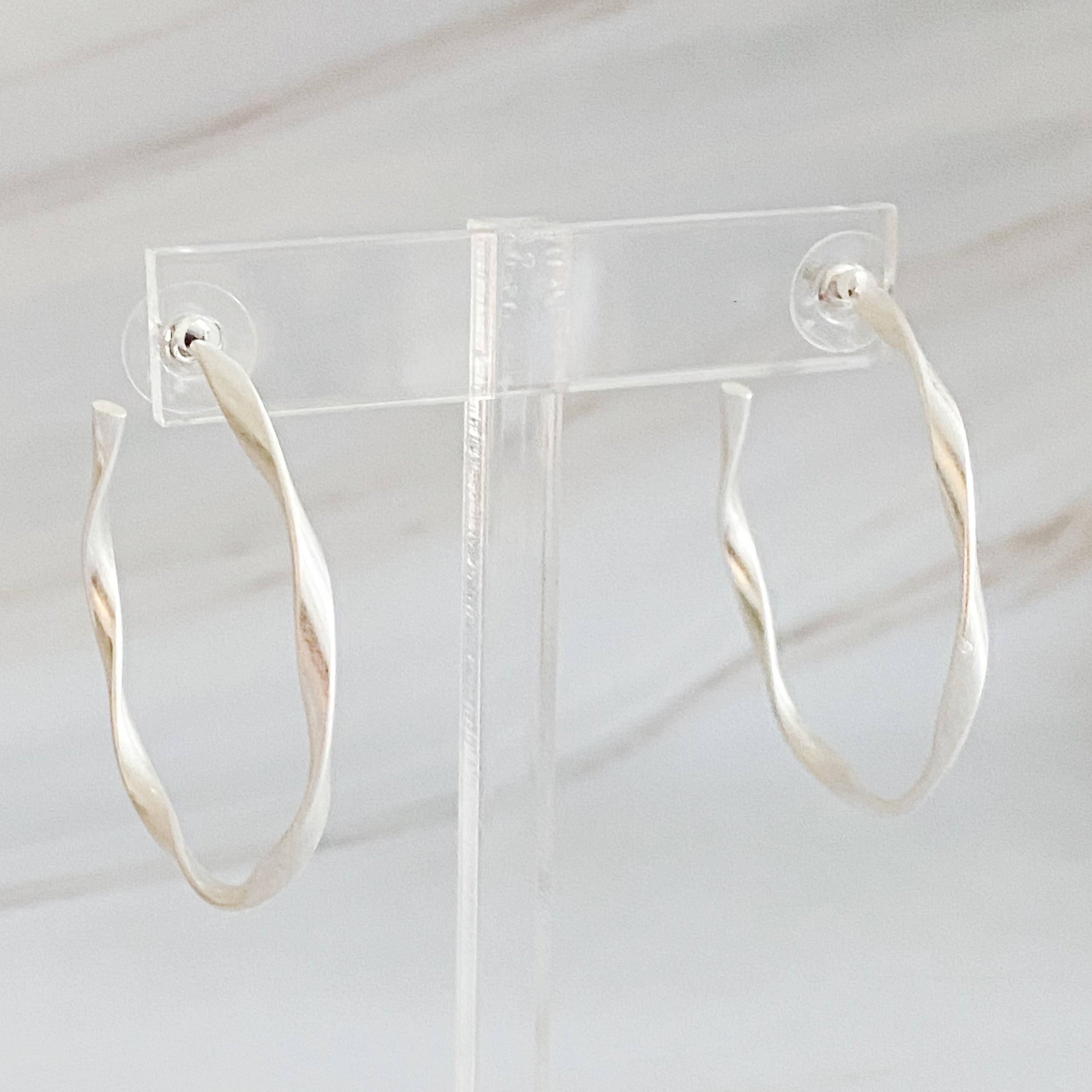 Gentle Wave Sleek Hoop Earrings with a softly twisted design and matte finish, showcasing their elegant and modern style.