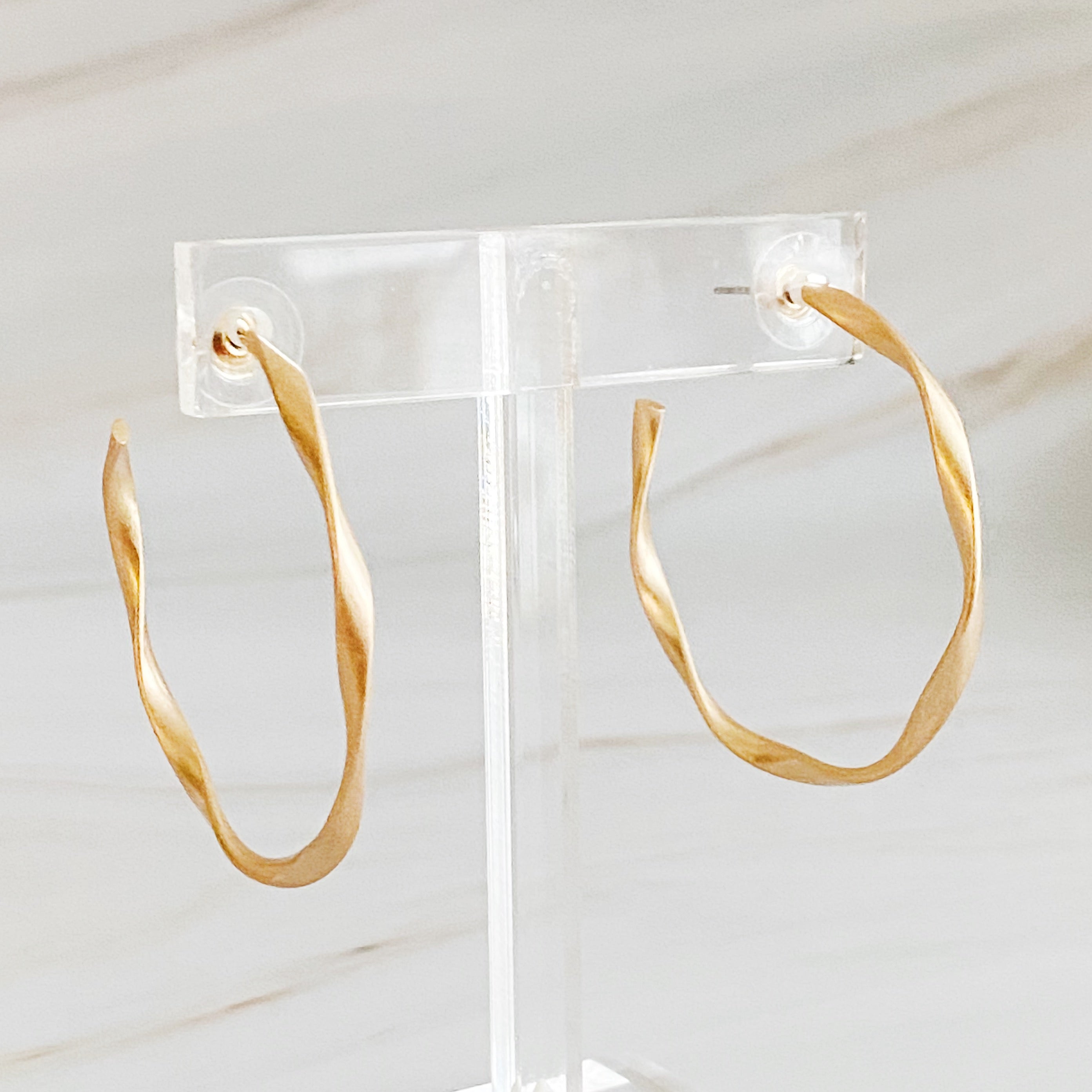 Gentle Wave Sleek Hoop Earrings with a softly twisted design and matte finish, showcasing their elegant and modern style.