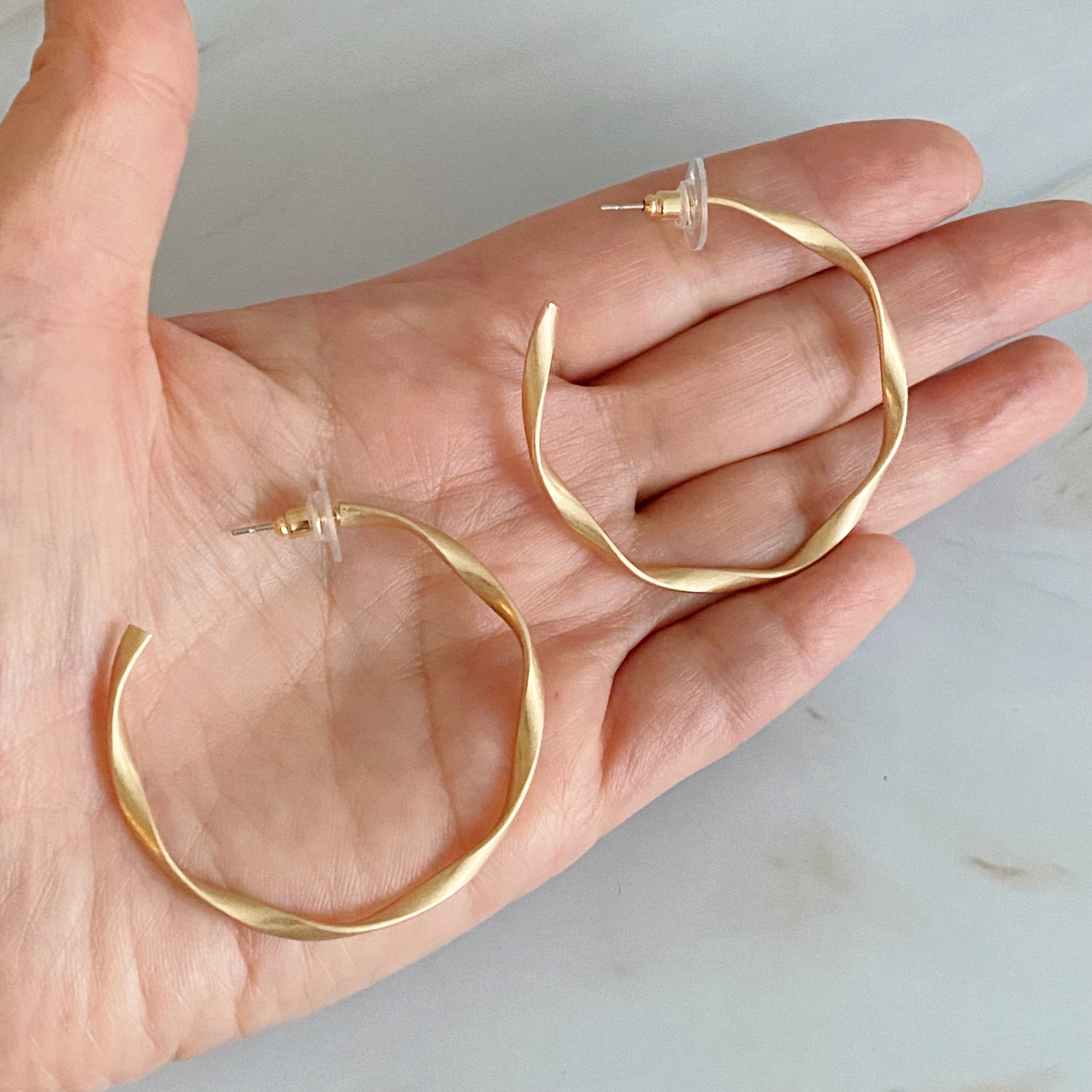 Gentle Wave Sleek Hoop Earrings with a softly twisted design and matte finish, showcasing their elegant and modern style.