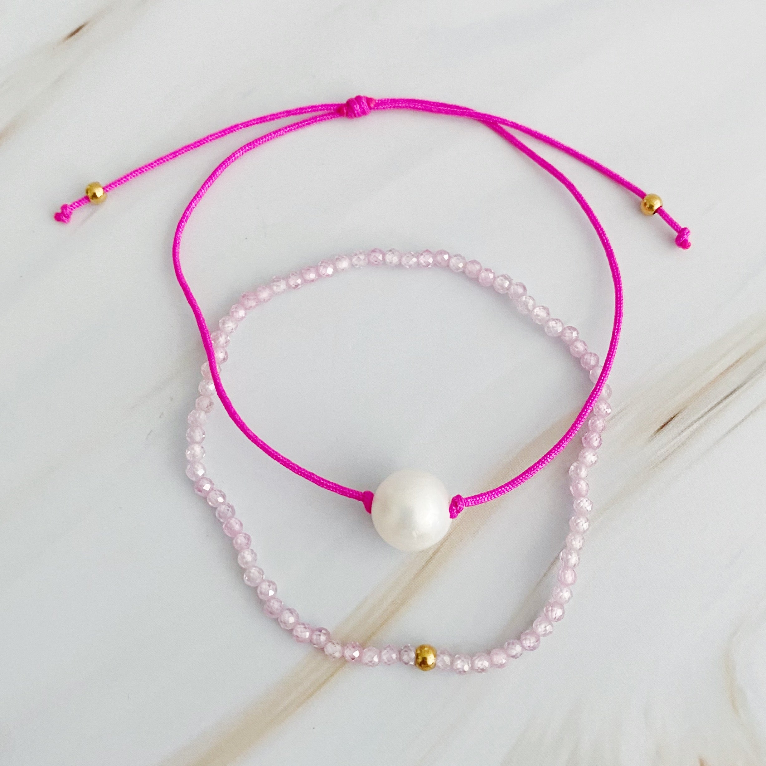 Genuine Pearl Color Dream Bracelet Set of 2 featuring freshwater pearls, colorful threads, and sparkly glass beads, elegantly displayed with a cream velvet bow.