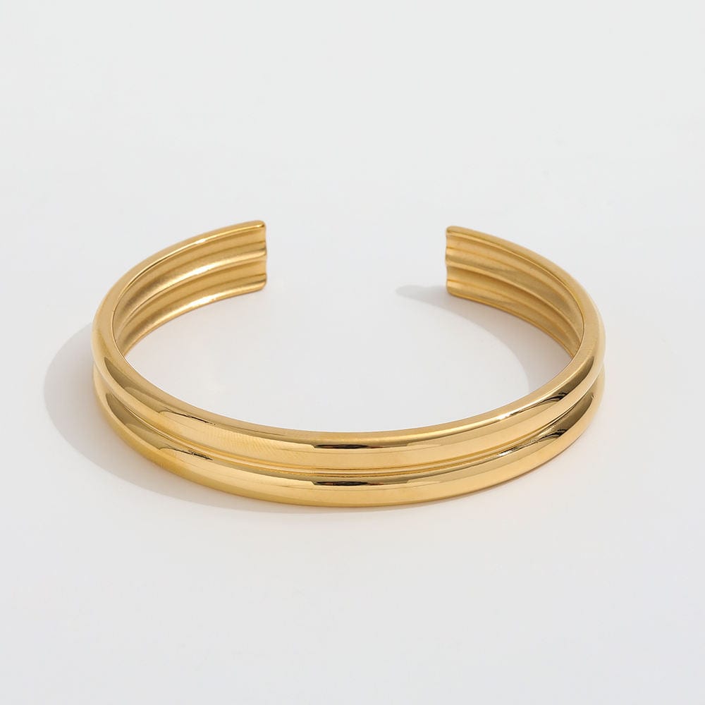 Gil Wide Polished Cuff Bracelet in Gold, showcasing its shiny stainless steel and 18K gold plating with an adjustable open cuff design.