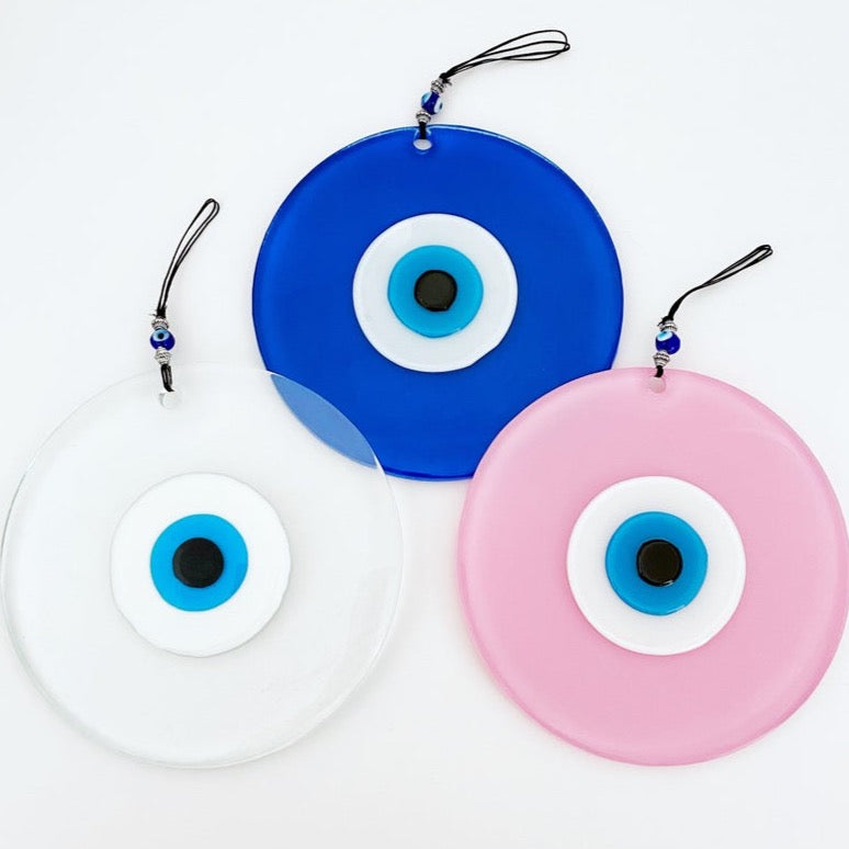 Handmade Glass Evil Eye Bead in clear, blue, and pink colors, showcasing unique craftsmanship and vibrant design.