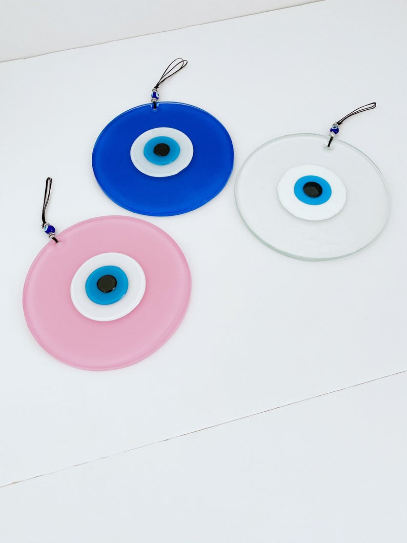 Handmade Glass Evil Eye Bead in clear, blue, and pink colors, showcasing unique craftsmanship and vibrant design.