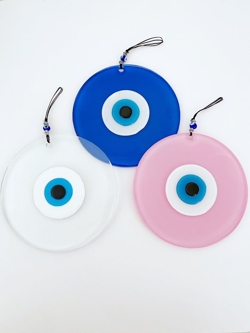 Handmade Glass Evil Eye Bead in clear, blue, and pink colors, showcasing unique craftsmanship and vibrant design.