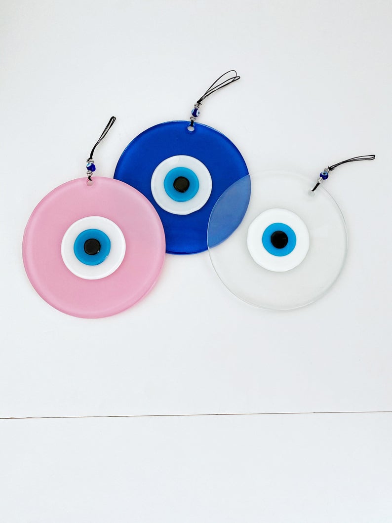 Handmade Glass Evil Eye Bead in clear, blue, and pink colors, showcasing unique craftsmanship and vibrant design.