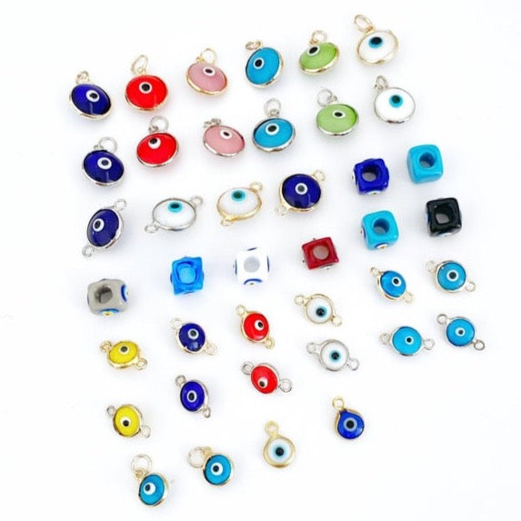 A collection of 5 Glass Evil Eye Charms made from Murano glass, showcasing various designs and vibrant colors, perfect for DIY jewelry making.