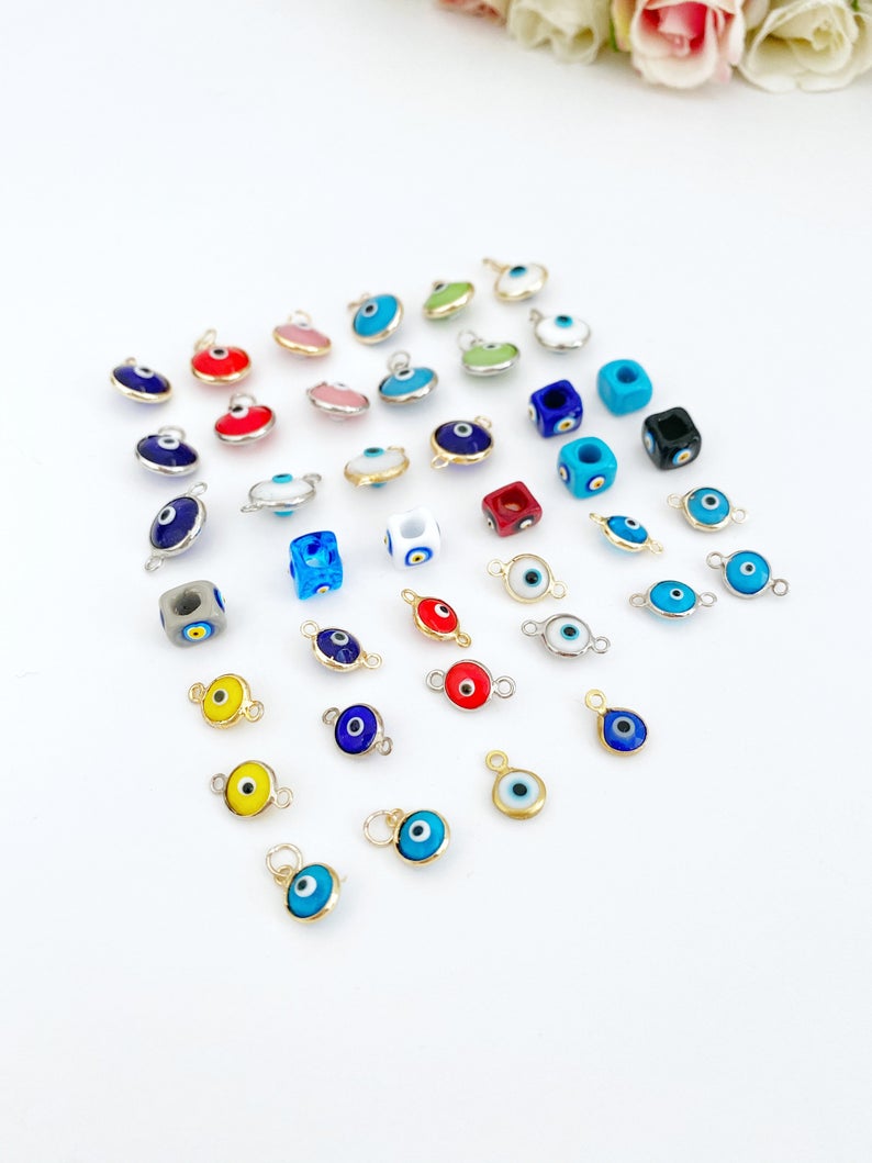 A collection of 5 Glass Evil Eye Charms made from Murano glass, showcasing various designs and vibrant colors, perfect for DIY jewelry making.