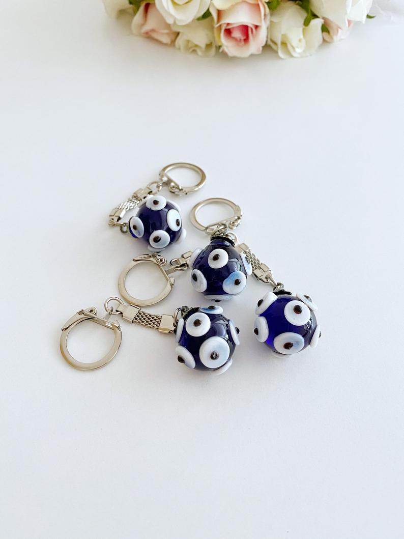 A beautiful Glass Evil Eye Keychain featuring a blue glass bead, symbolizing protection and luck, attached to a silver keyring.