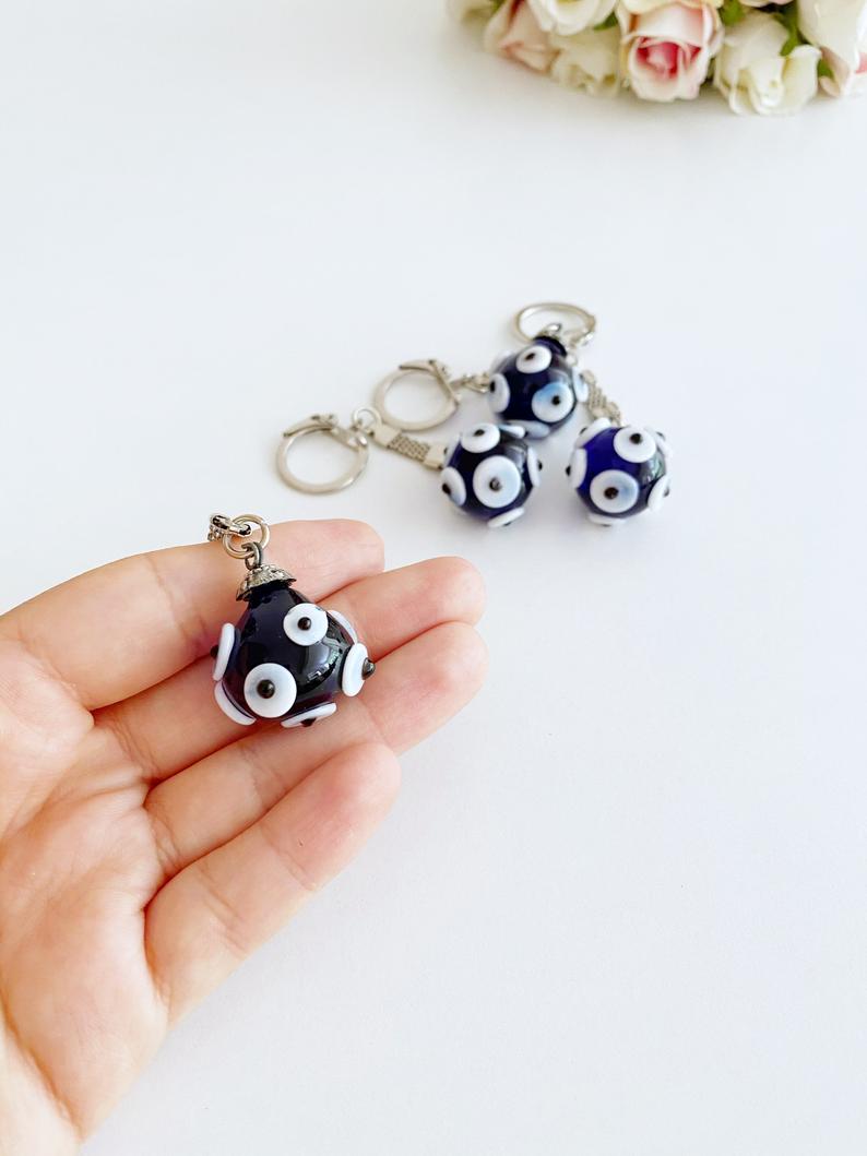 A beautiful Glass Evil Eye Keychain featuring a blue glass bead, symbolizing protection and luck, attached to a silver keyring.