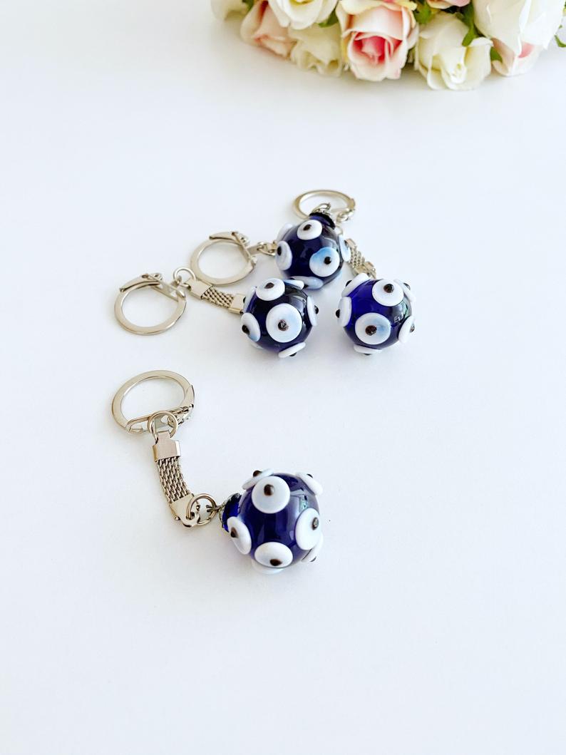 A beautiful Glass Evil Eye Keychain featuring a blue glass bead, symbolizing protection and luck, attached to a silver keyring.