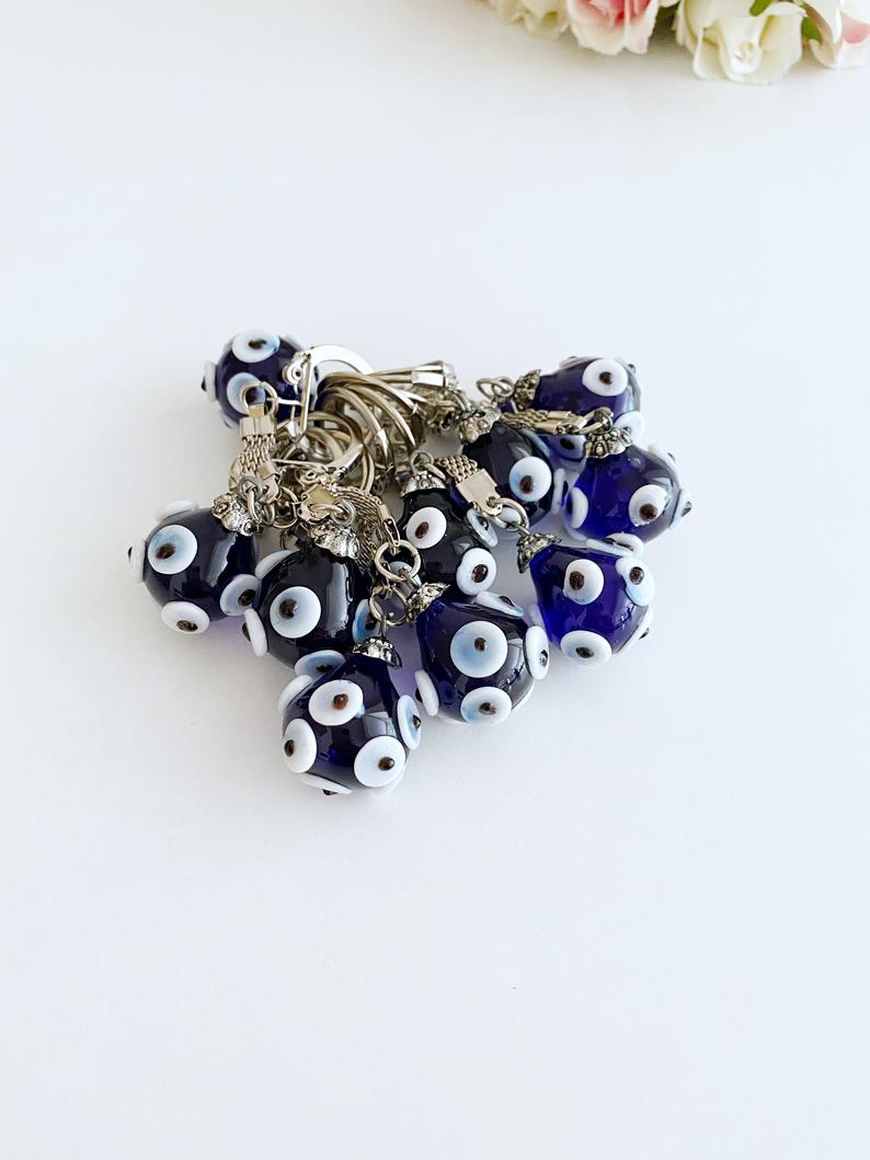 A beautiful Glass Evil Eye Keychain featuring a blue glass bead, symbolizing protection and luck, attached to a silver keyring.