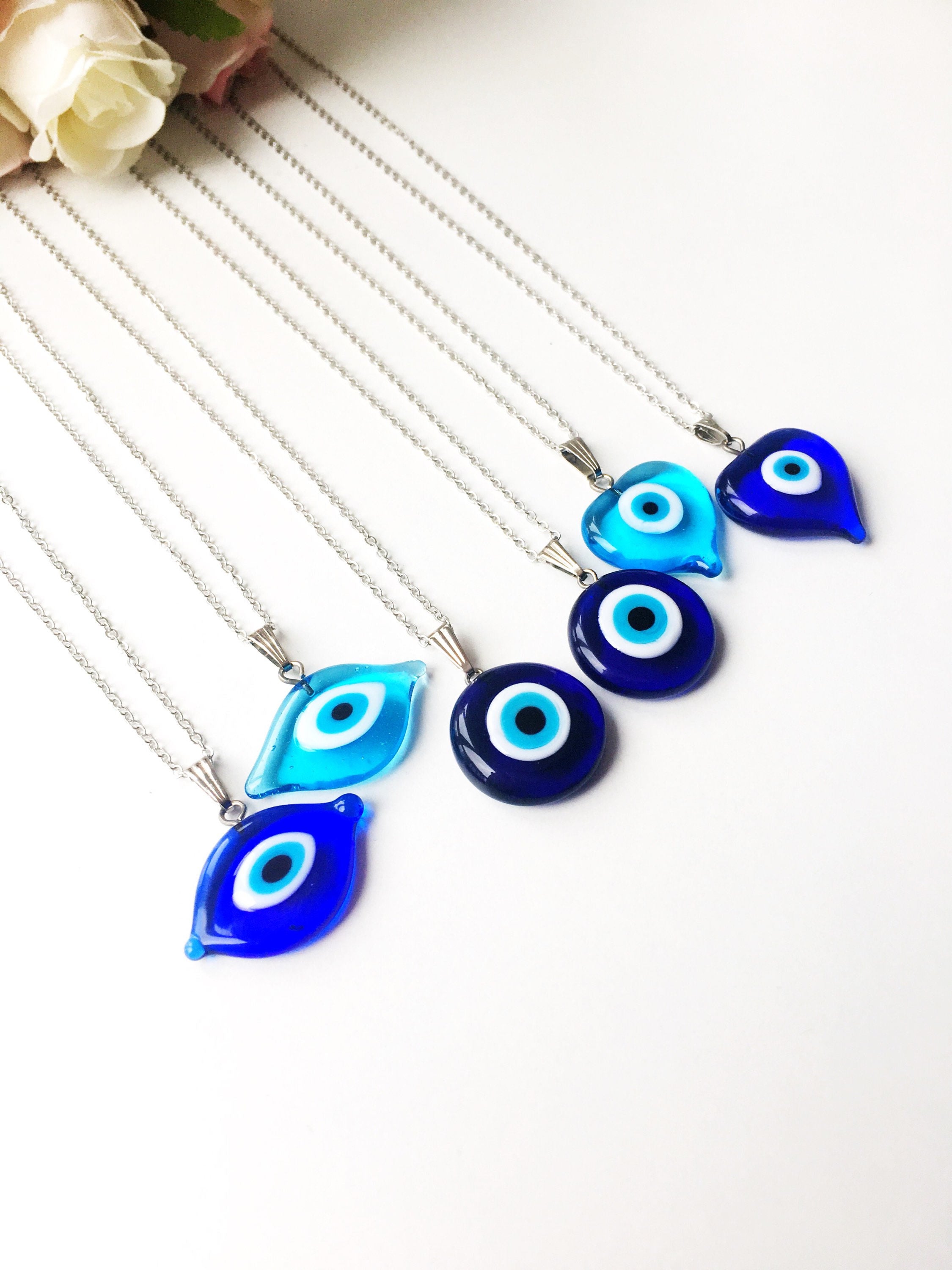 A beautiful Glass Evil Eye Necklace featuring a blue evil eye bead on a stainless steel chain, available in round, heart, and oval shapes.