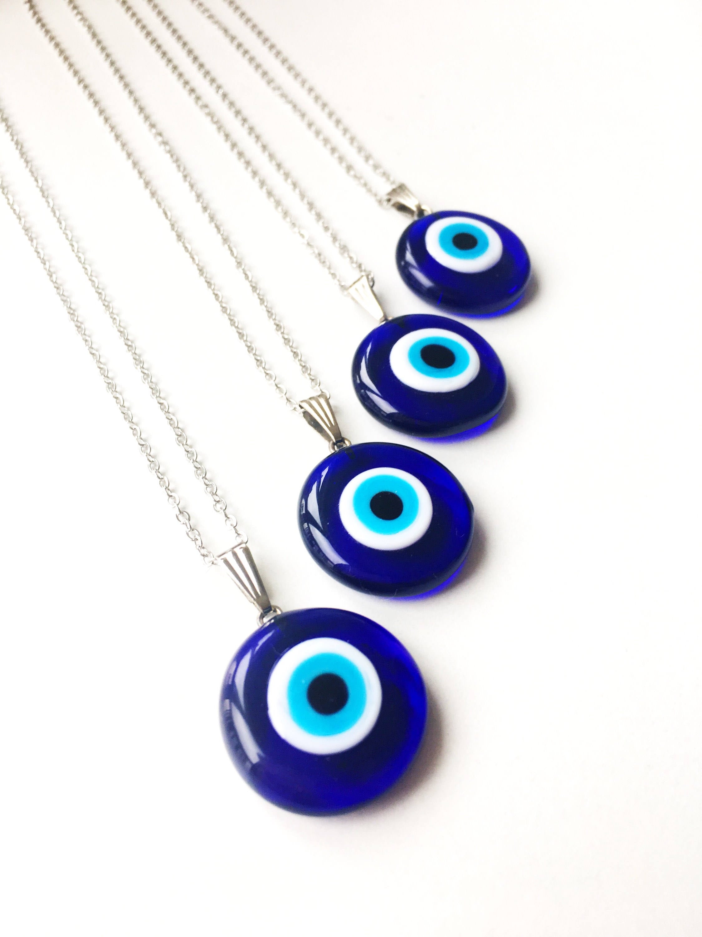 A beautiful Glass Evil Eye Necklace featuring a blue evil eye bead on a stainless steel chain, available in round, heart, and oval shapes.