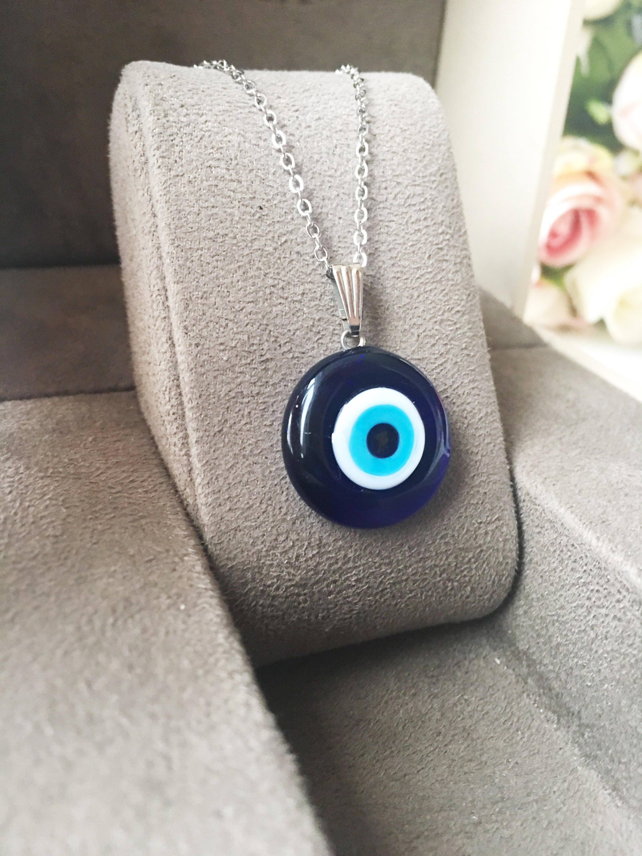 A beautiful Glass Evil Eye Necklace featuring a blue evil eye bead on a stainless steel chain, available in round, heart, and oval shapes.