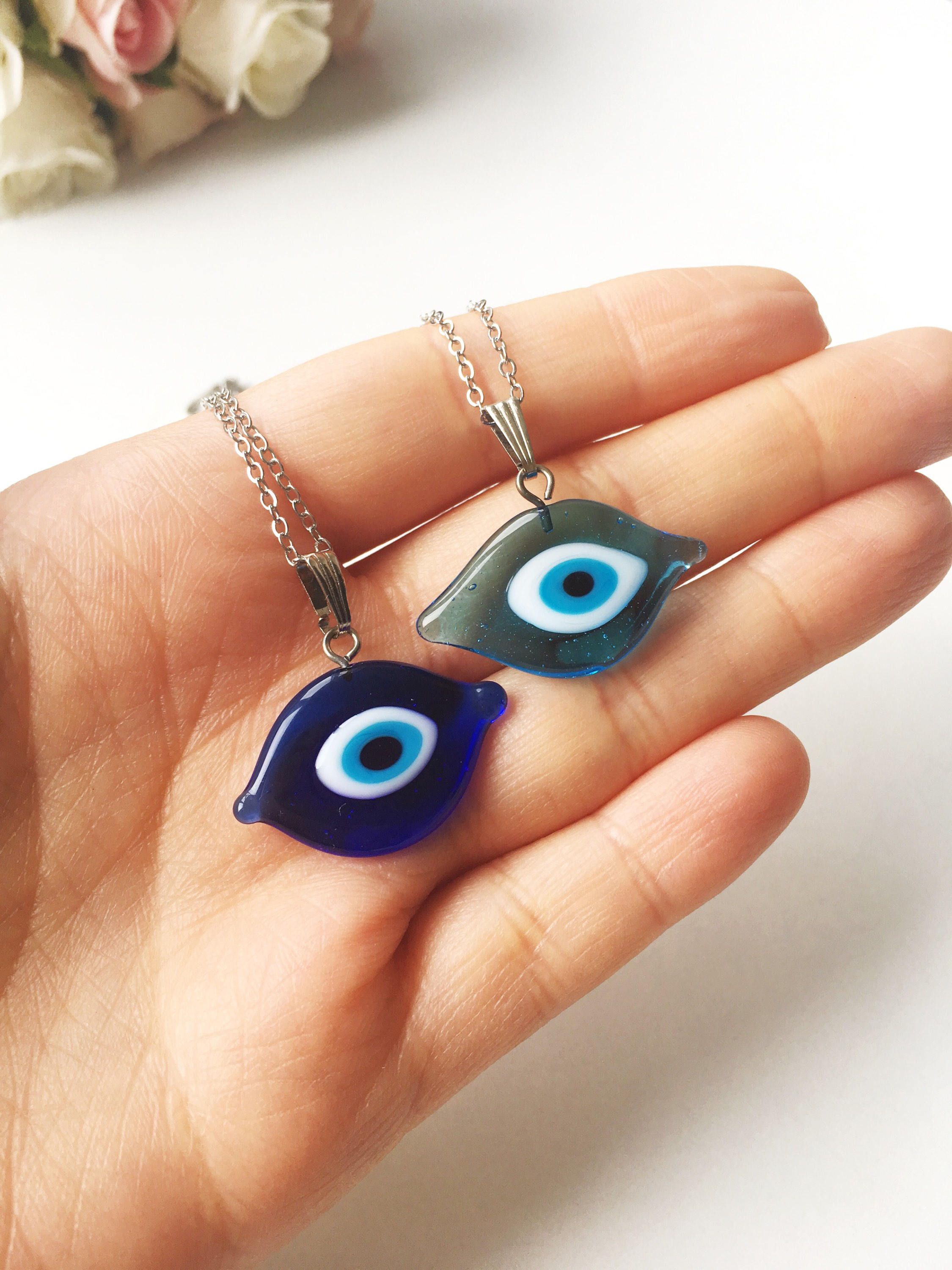 A beautiful Glass Evil Eye Necklace featuring a blue evil eye bead on a stainless steel chain, available in round, heart, and oval shapes.