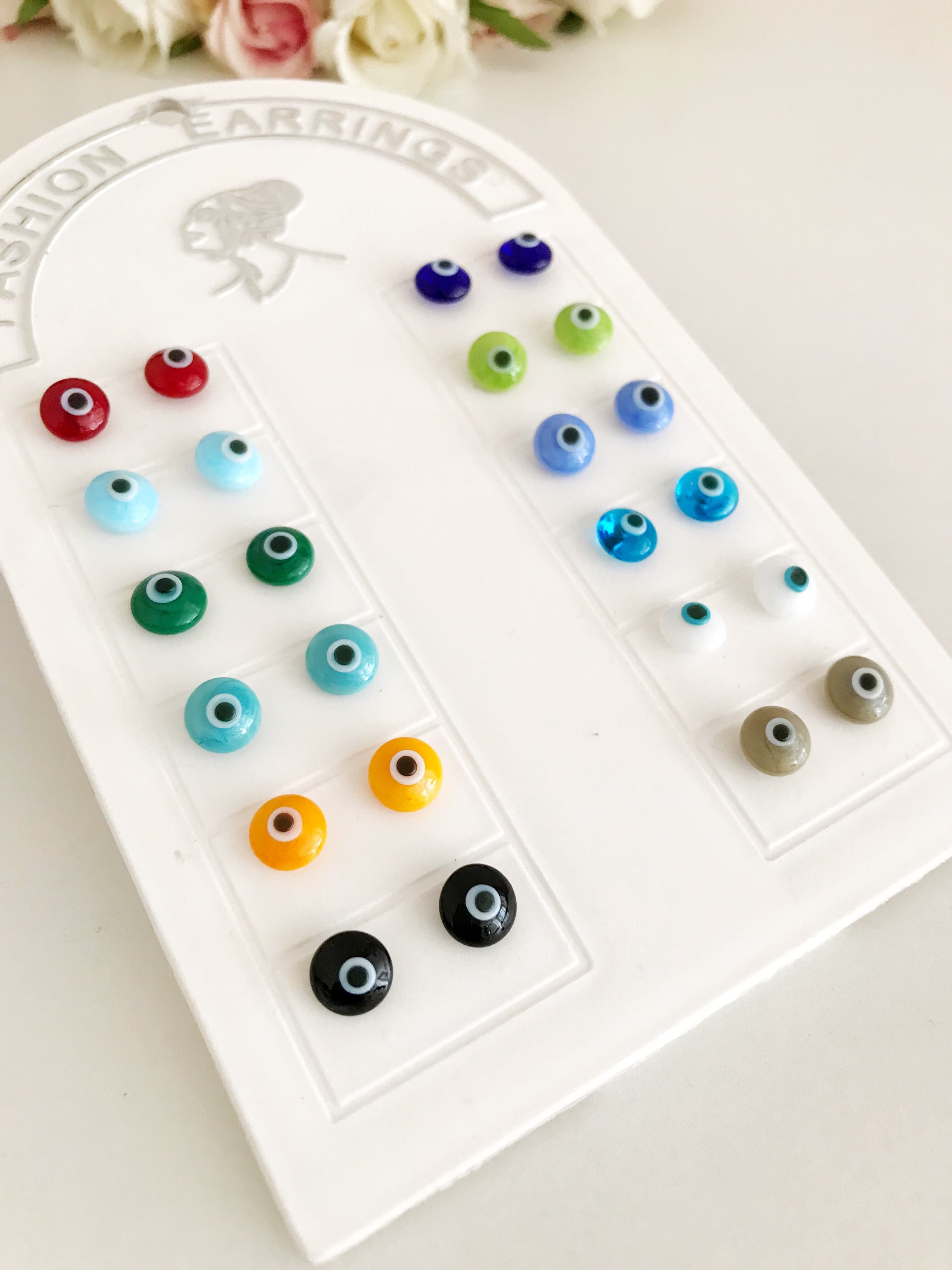 A pair of handmade glass evil eye stud earrings in various vibrant colors, symbolizing protection and good fortune.