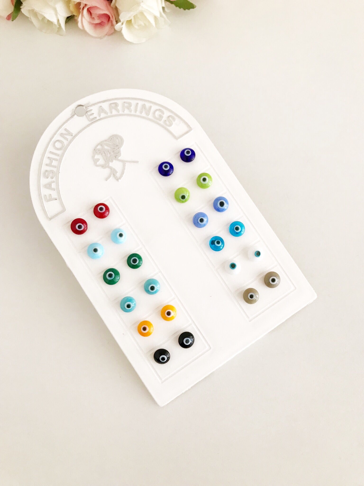 A pair of handmade glass evil eye stud earrings in various vibrant colors, symbolizing protection and good fortune.