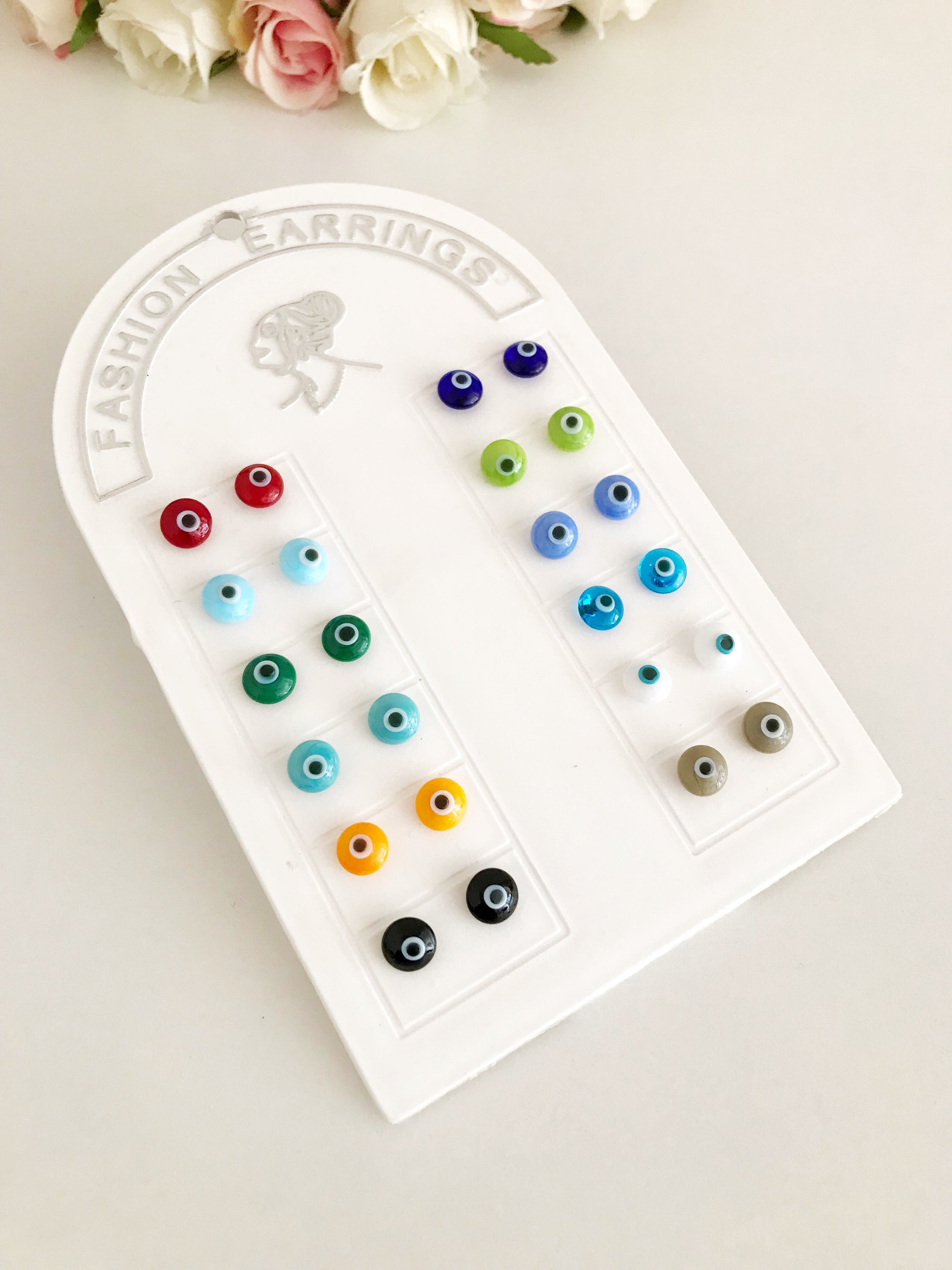 A pair of handmade glass evil eye stud earrings in various vibrant colors, symbolizing protection and good fortune.