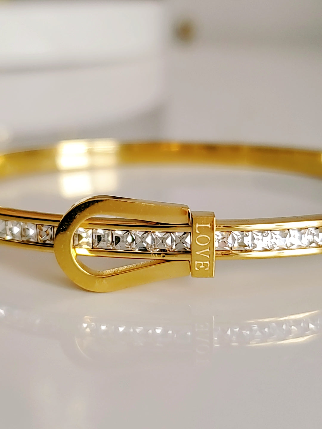 Elegant Gold Belt Bangle made of 316L stainless steel with simulated diamonds, featuring a unique belt design and snap-on closure.