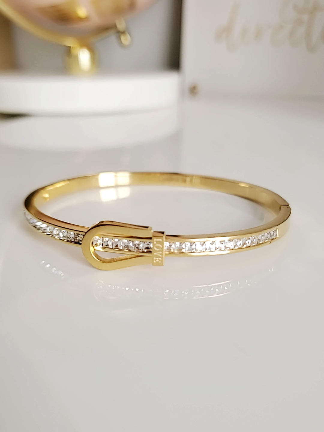 Elegant Gold Belt Bangle made of 316L stainless steel with simulated diamonds, featuring a unique belt design and snap-on closure.