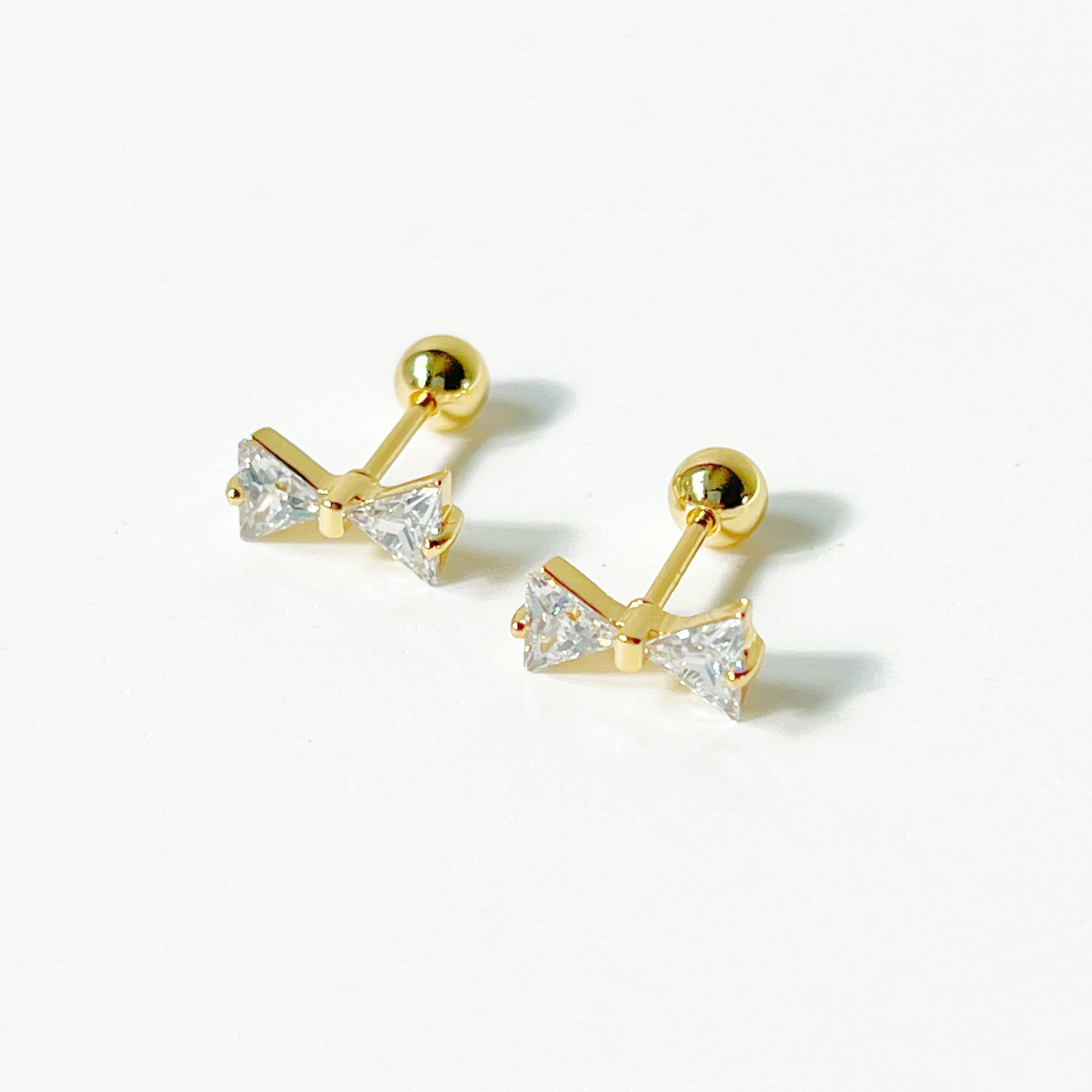 Gold Bow Zircon Earrings featuring a small bow design with clear zircon stones, set on a hypoallergenic surgical steel base.