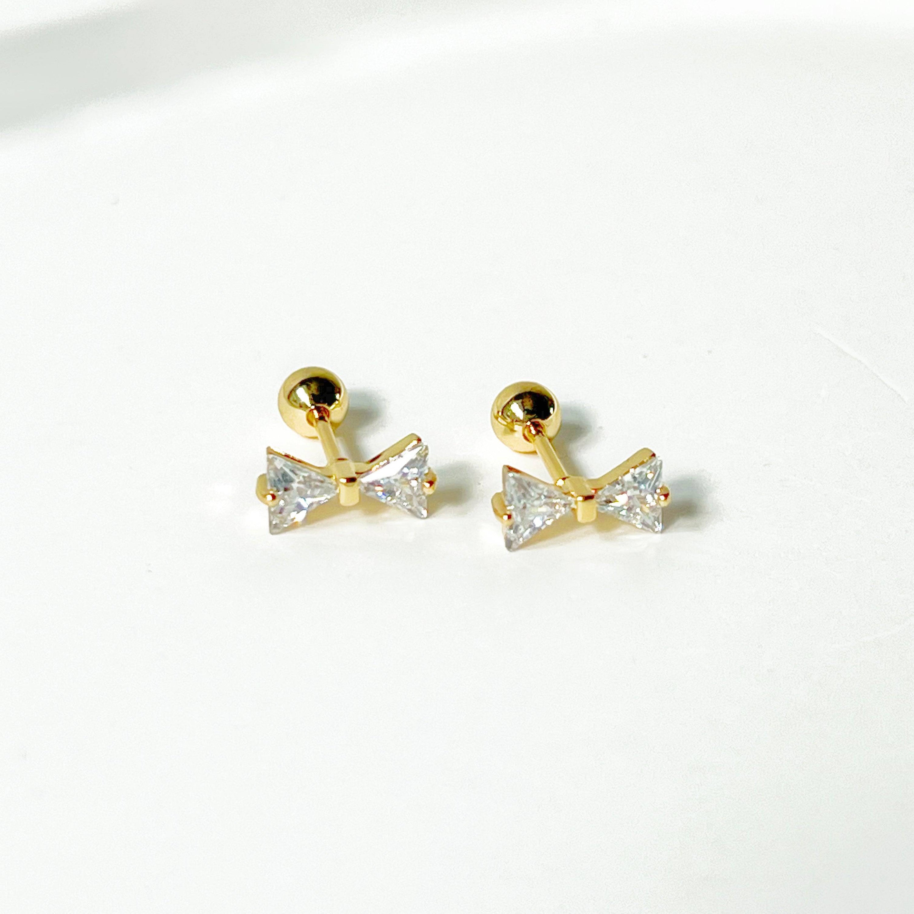 Gold Bow Zircon Earrings featuring a small bow design with clear zircon stones, set on a hypoallergenic surgical steel base.