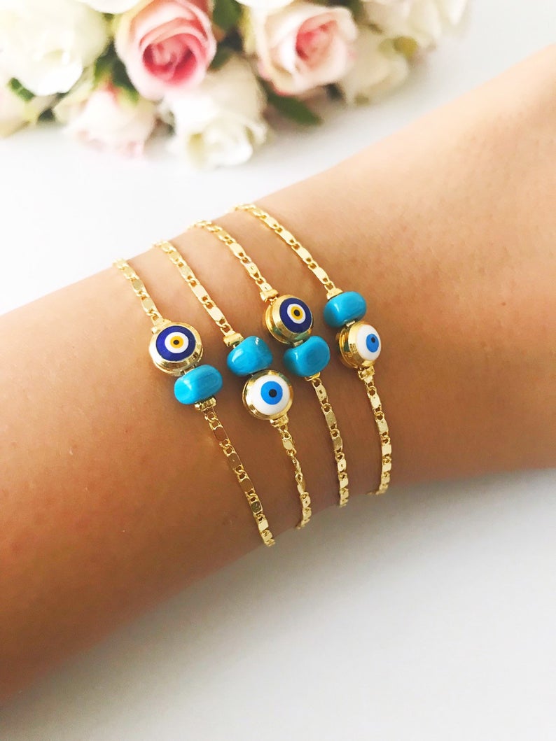 A beautiful gold chain bracelet featuring a blue and white evil eye bead, symbolizing protection and style, handmade with care.