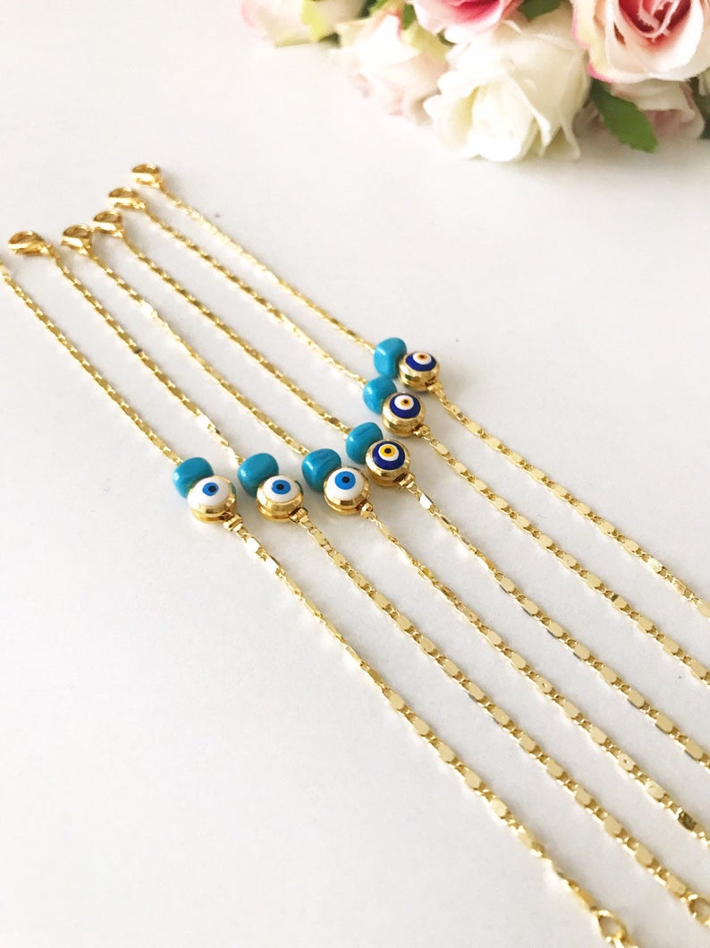 A beautiful gold chain bracelet featuring a blue and white evil eye bead, symbolizing protection and style, handmade with care.