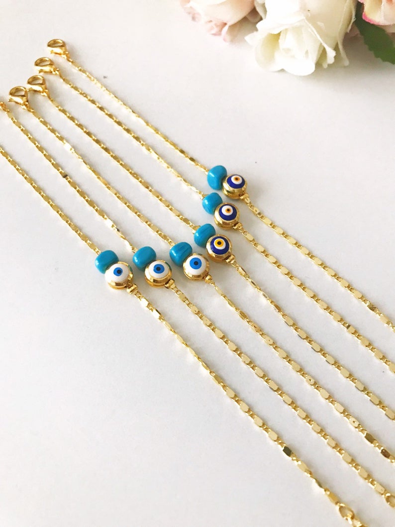 A beautiful gold chain bracelet featuring a blue and white evil eye bead, symbolizing protection and style, handmade with care.