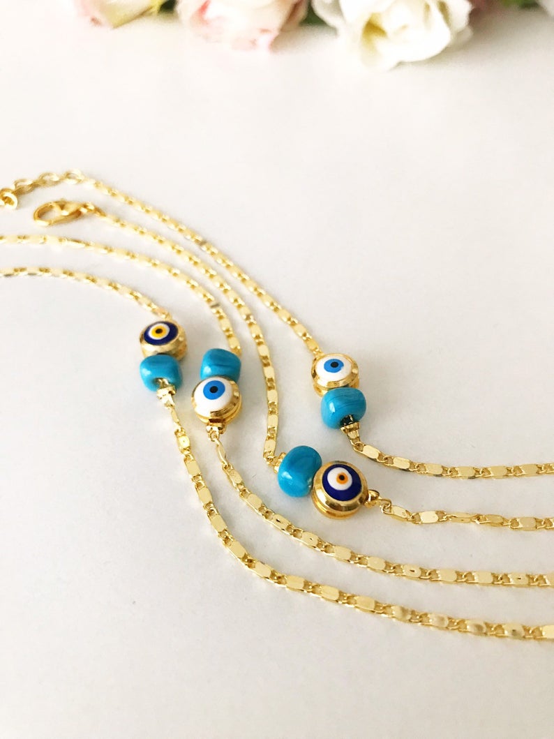 A beautiful gold chain bracelet featuring a blue and white evil eye bead, symbolizing protection and style, handmade with care.