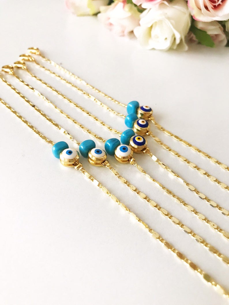 A beautiful gold chain bracelet featuring a blue and white evil eye bead, symbolizing protection and style, handmade with care.