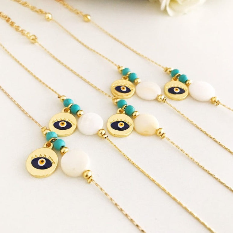 Gold Chain Evil Eye Bracelet featuring a gold evil eye charm and mother of pearl charm, elegantly designed with an adjustable length.