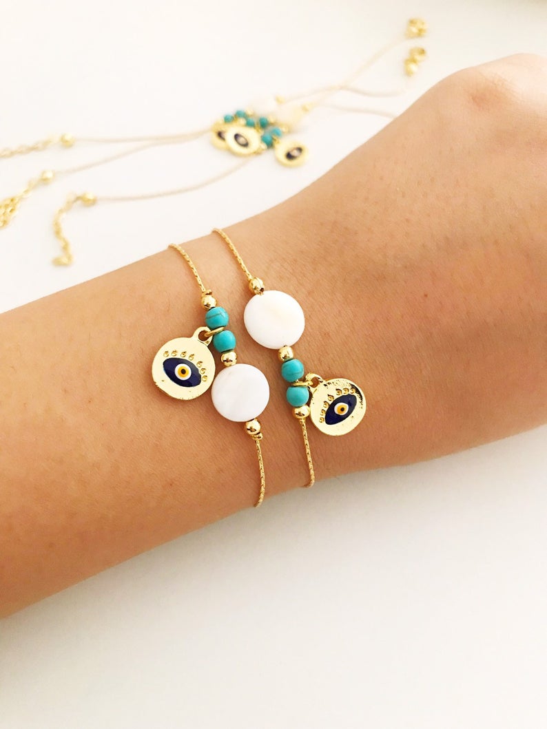 Gold Chain Evil Eye Bracelet featuring a gold evil eye charm and mother of pearl charm, elegantly designed with an adjustable length.