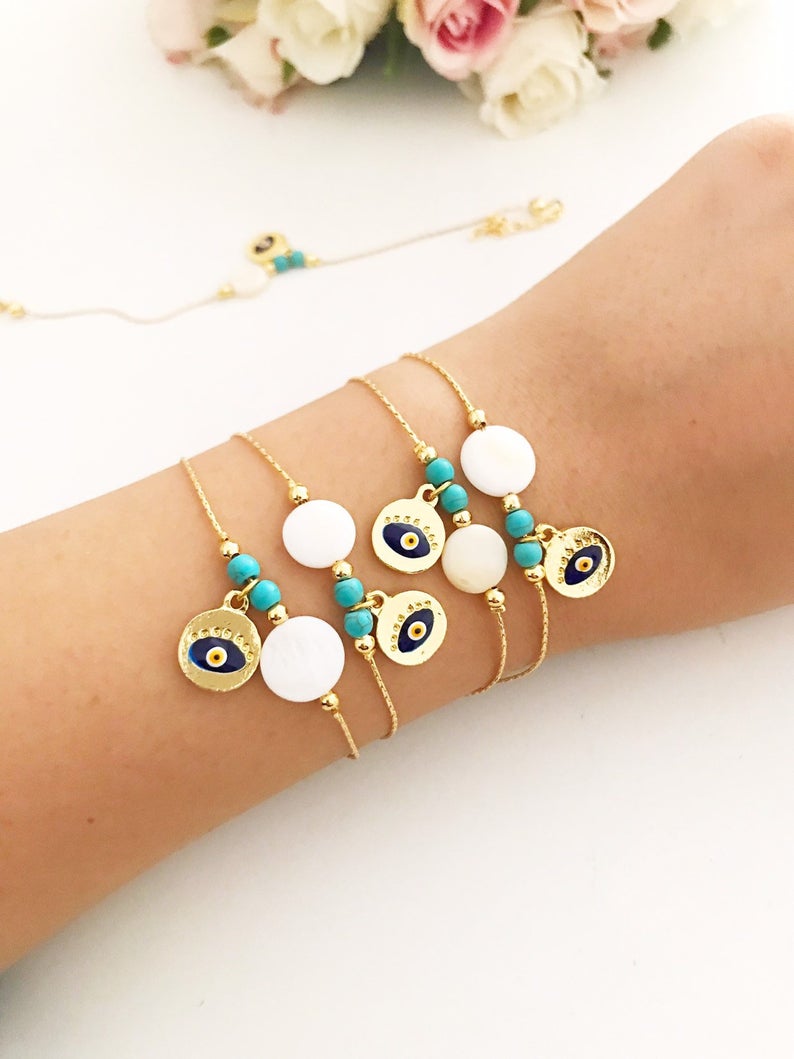 Gold Chain Evil Eye Bracelet featuring a gold evil eye charm and mother of pearl charm, elegantly designed with an adjustable length.