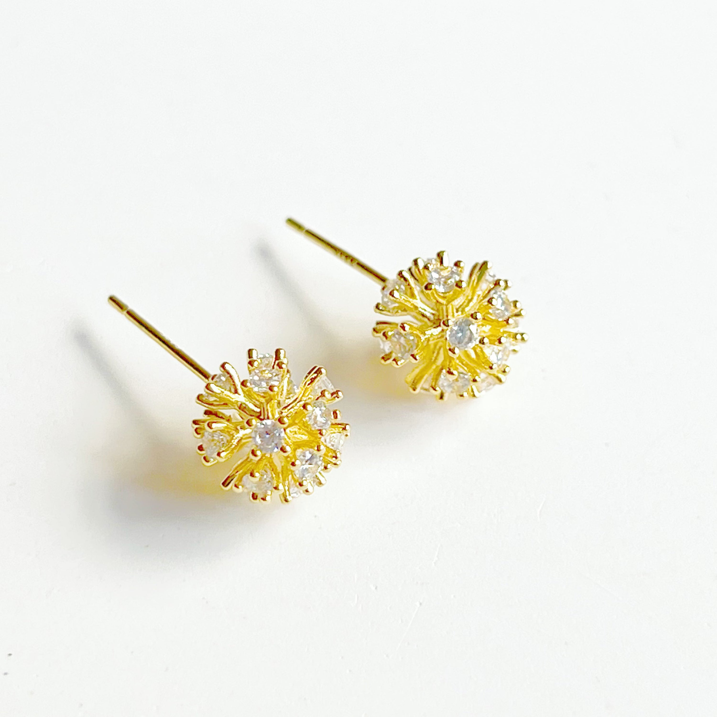 A pair of elegant gold crystal dandelion stud earrings featuring clear zircons, symbolizing hope and love.