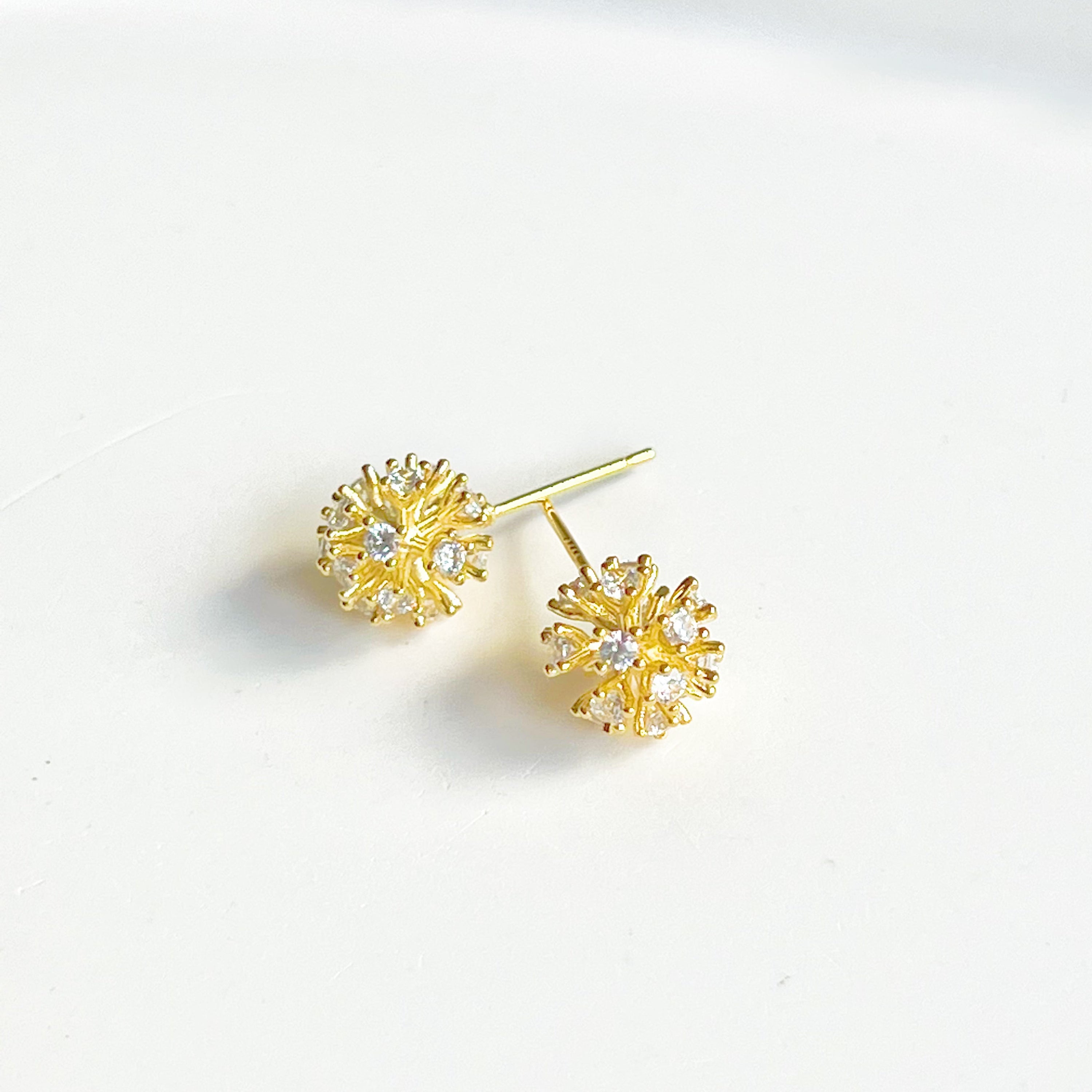 A pair of elegant gold crystal dandelion stud earrings featuring clear zircons, symbolizing hope and love.