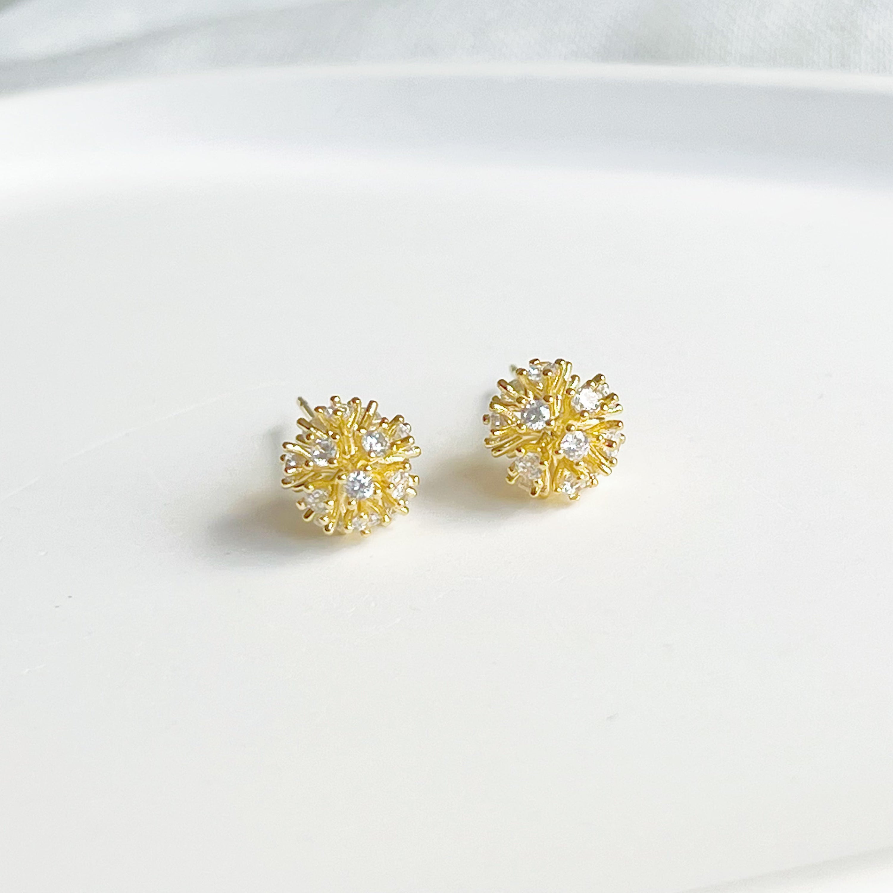 A pair of elegant gold crystal dandelion stud earrings featuring clear zircons, symbolizing hope and love.