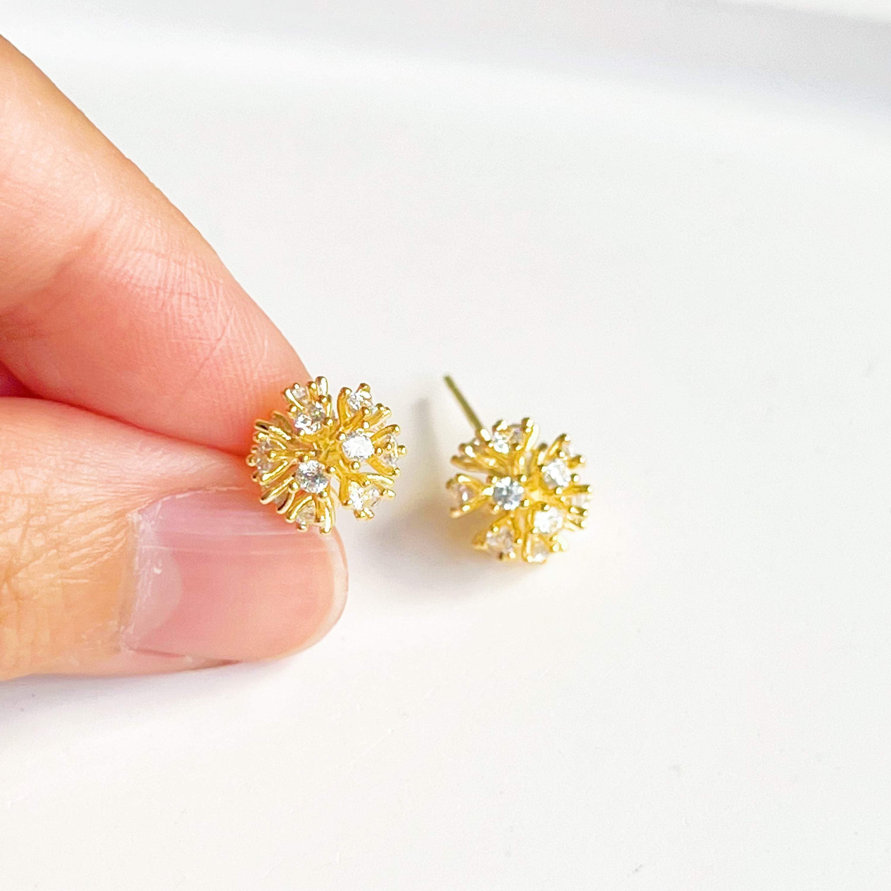 A pair of elegant gold crystal dandelion stud earrings featuring clear zircons, symbolizing hope and love.