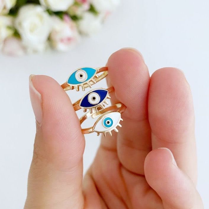 Gold Dainty Evil Eye Ring featuring a thin band and an oval evil eye charm in blue, turquoise, and white colors.